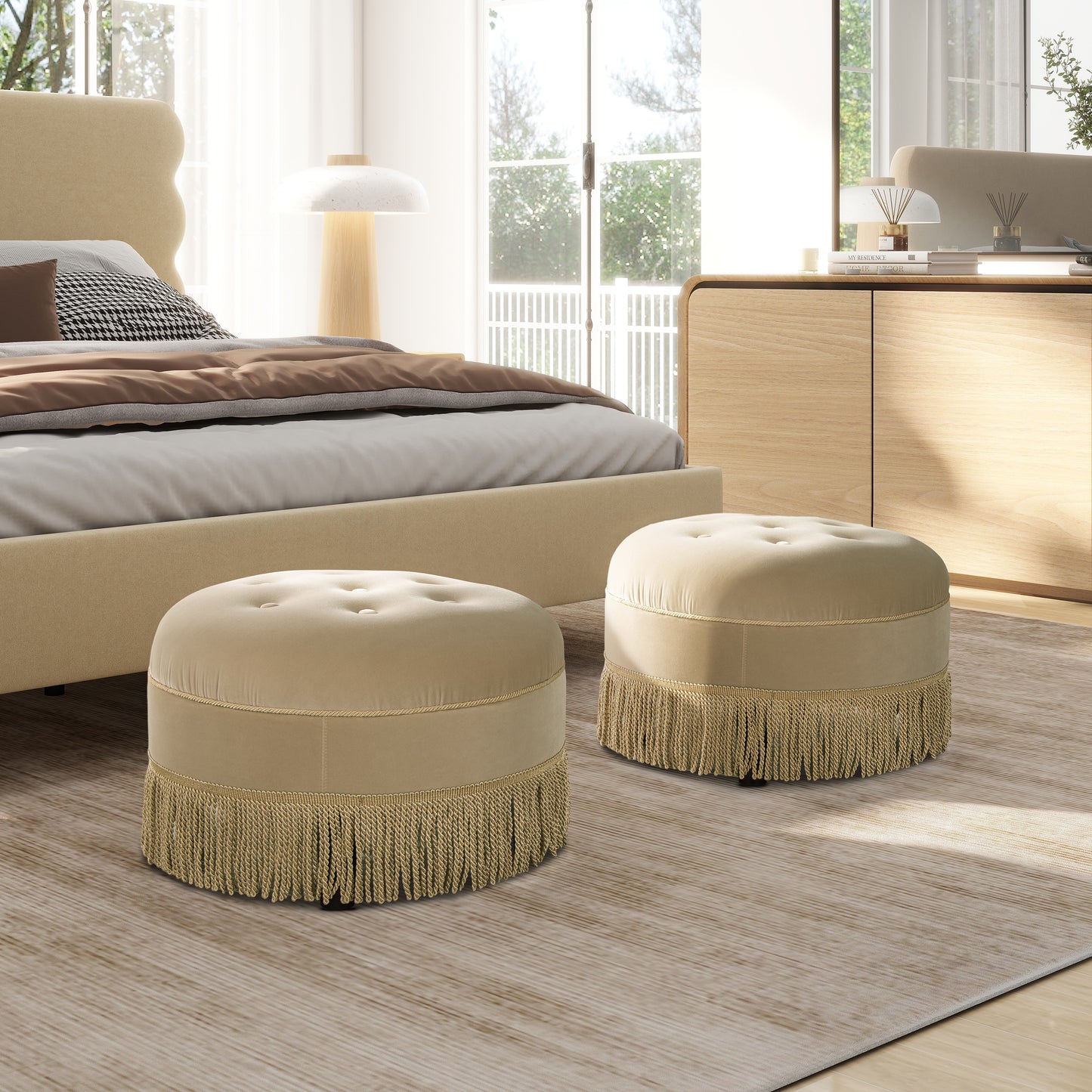 Round beige velvet ottoman with button tufting and ornate fringe detail