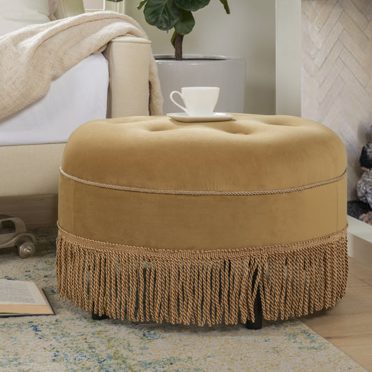 Tufted camel velvet ottoman with fringed base and decorative rope trim