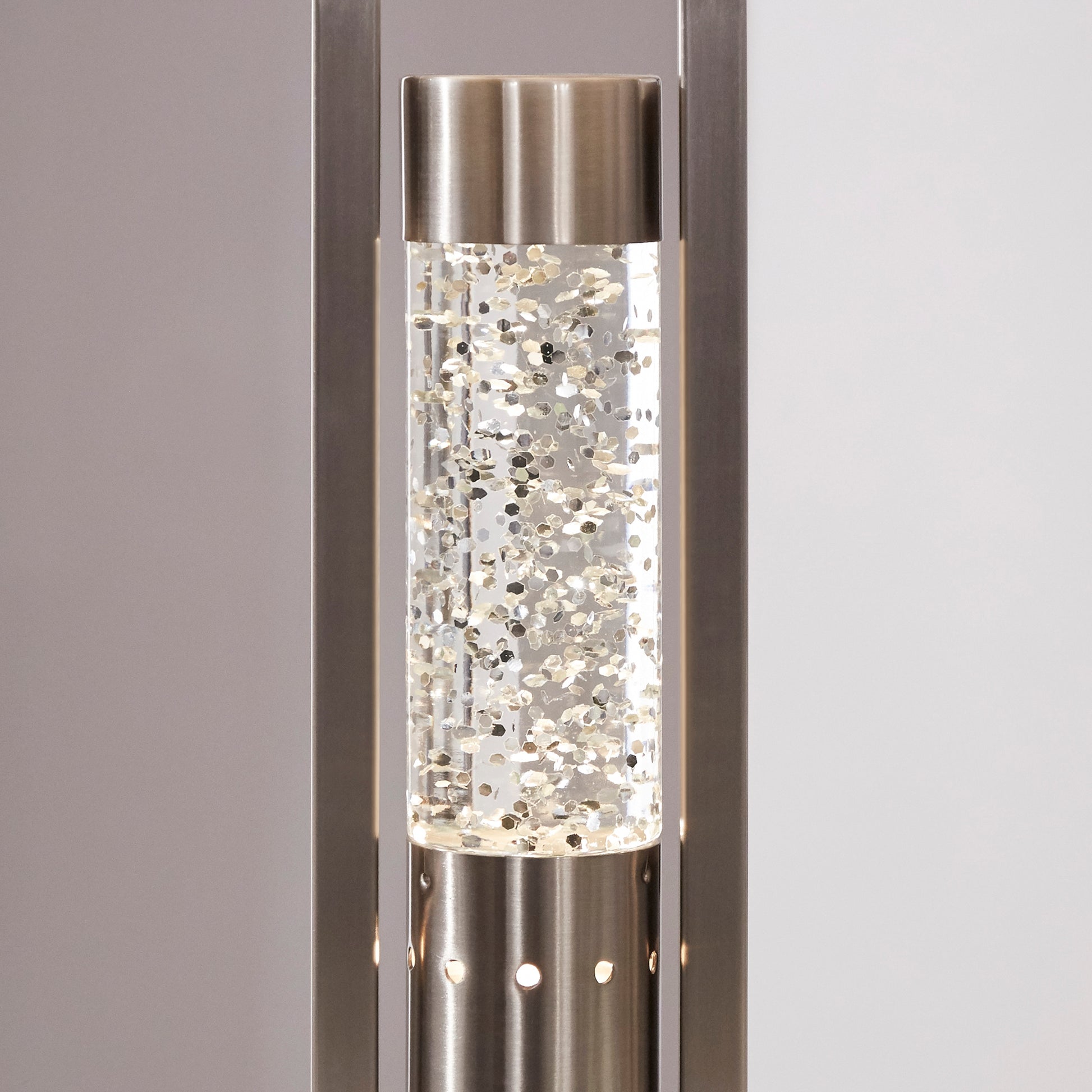 Sleek brushed nickel floor lamp with clear glass cylinder filled with shimmering gold glitter for ambient light