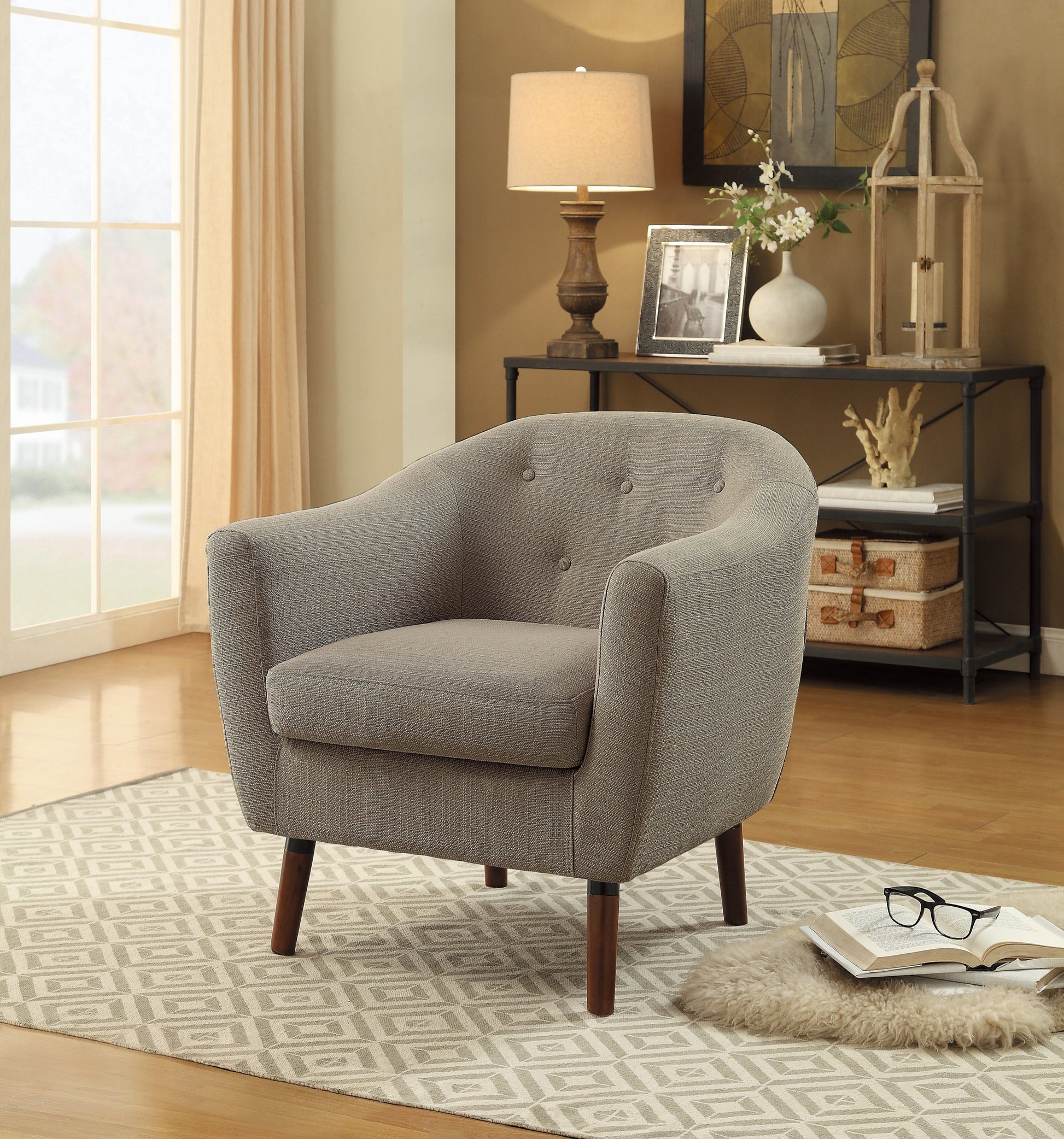 Gray upholstered armchair with tufted back and dark wood legs