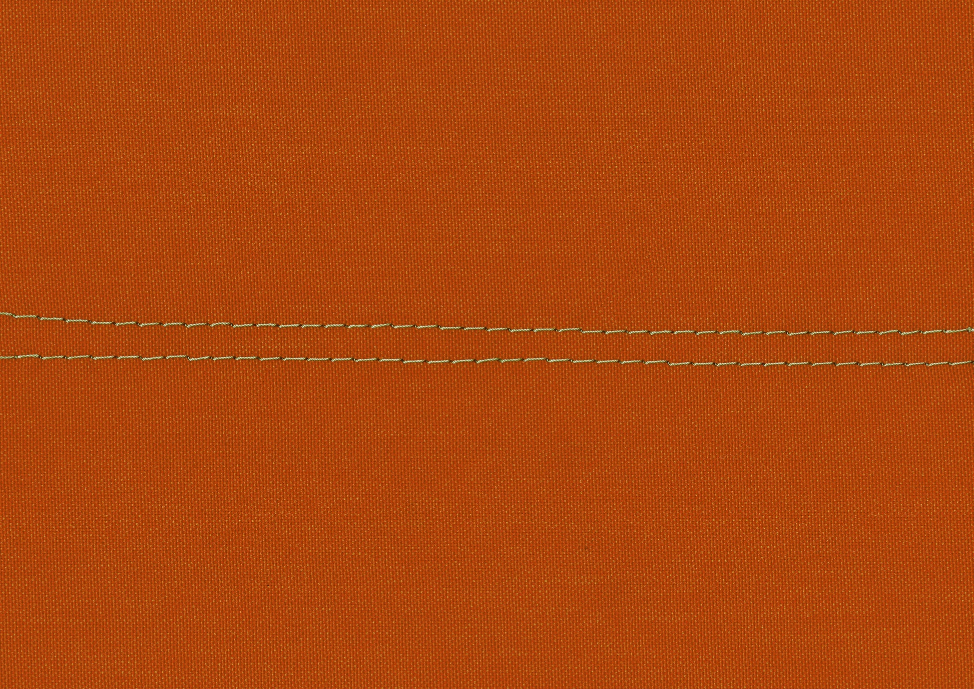 Closeup of burnt orange canvas fabric with double contrasting stitch detail