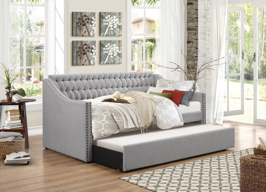 Tufted gray fabric daybed with pullout trundle and studded trim perfect for guest rooms