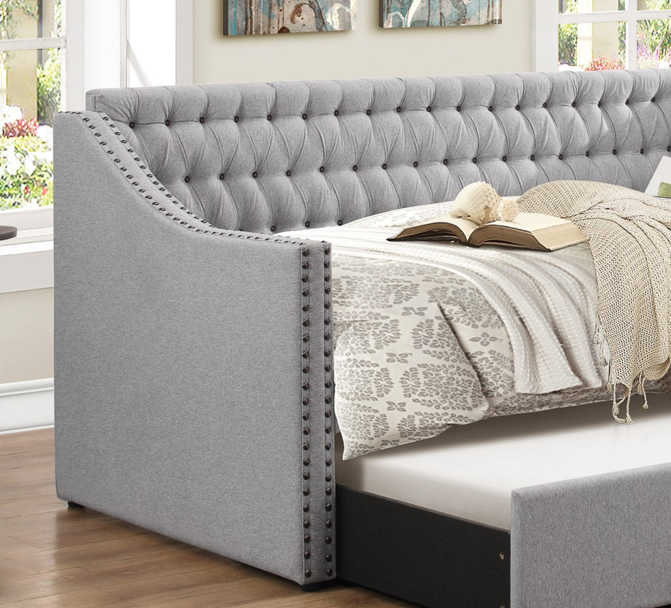 Gray upholstered daybed with tufted headboard and nailhead trim