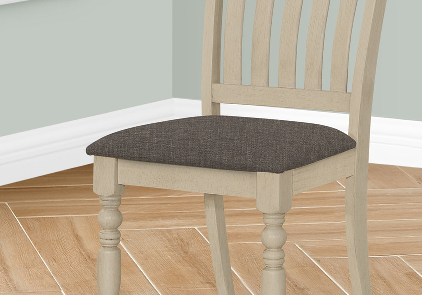 Light wood dining chair with dark grey upholstered seat and turned legs