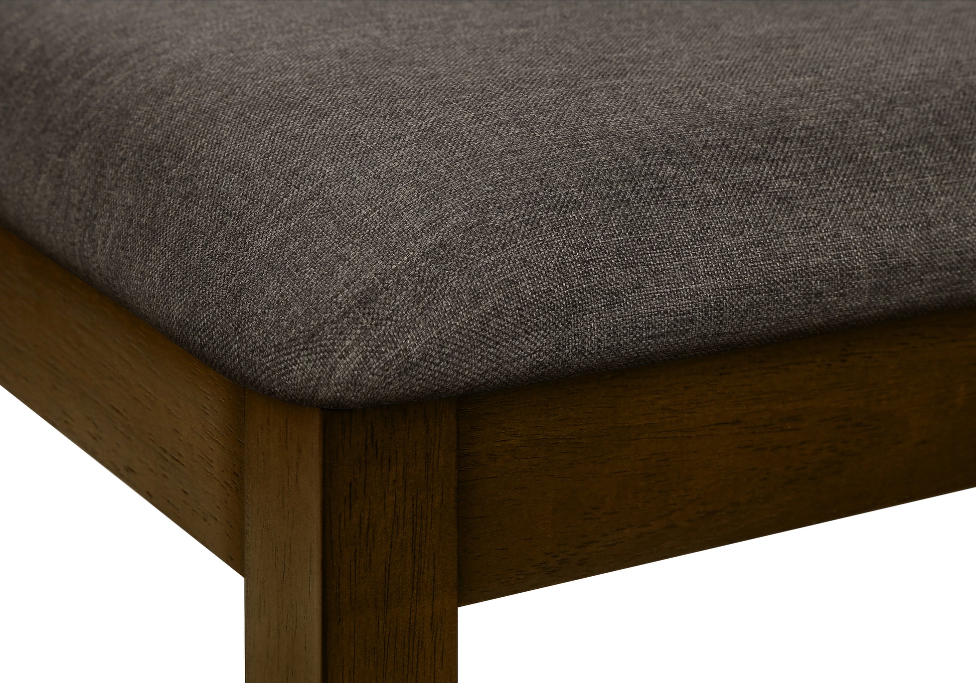 Closeup of a dark grey upholstered seat on a dark wood dining chair leg