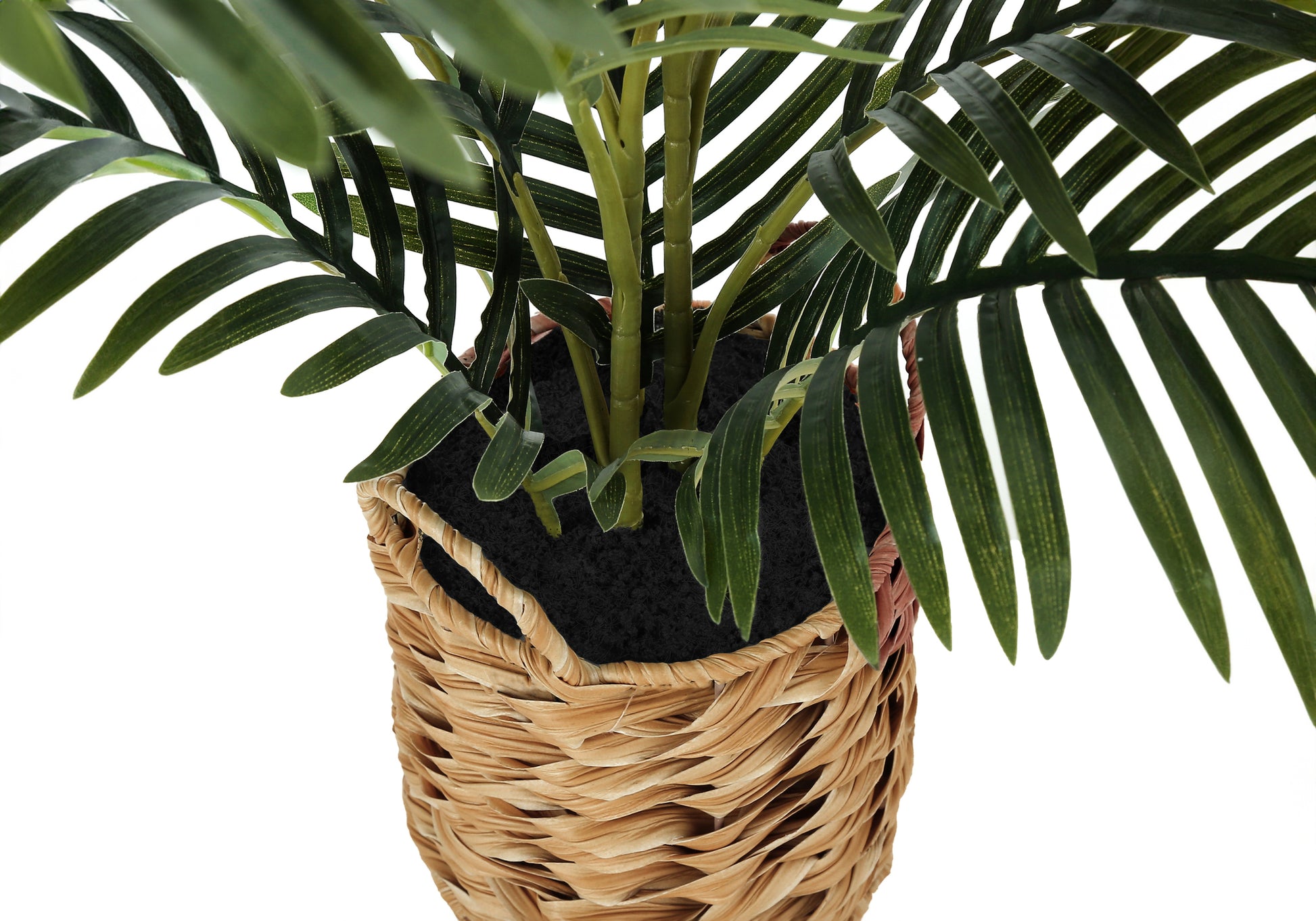 Closeup of a green faux palm plant in a woven basket planter adding tropical decor