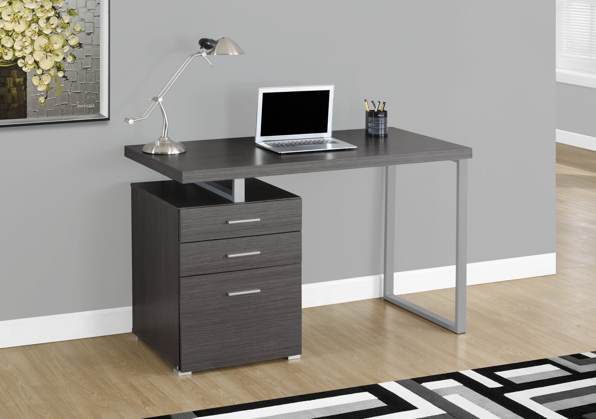Modern dark grey wood computer desk with three drawers and silver legs