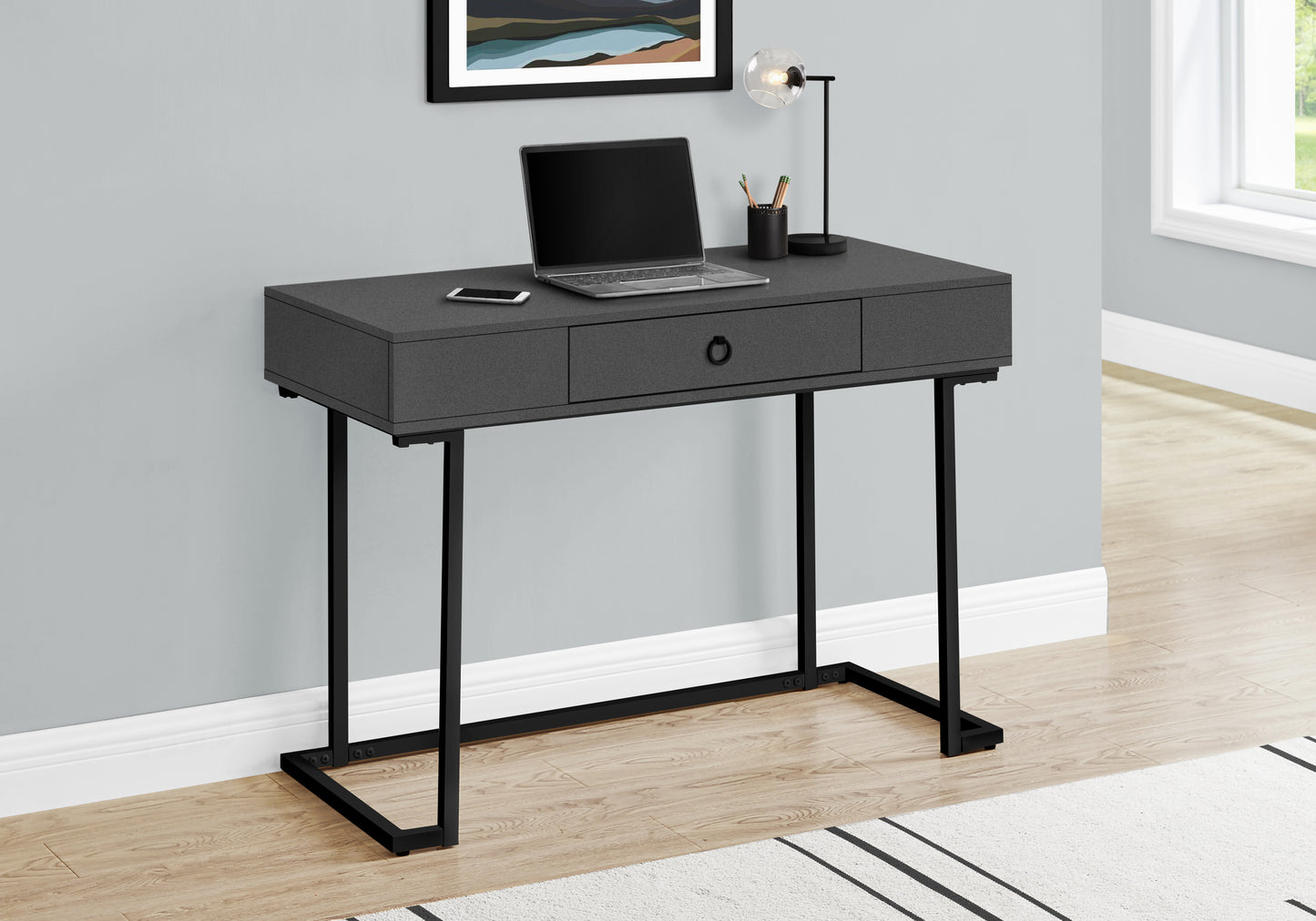 Charcoal gray modern desk with black metal legs laptop and lamp