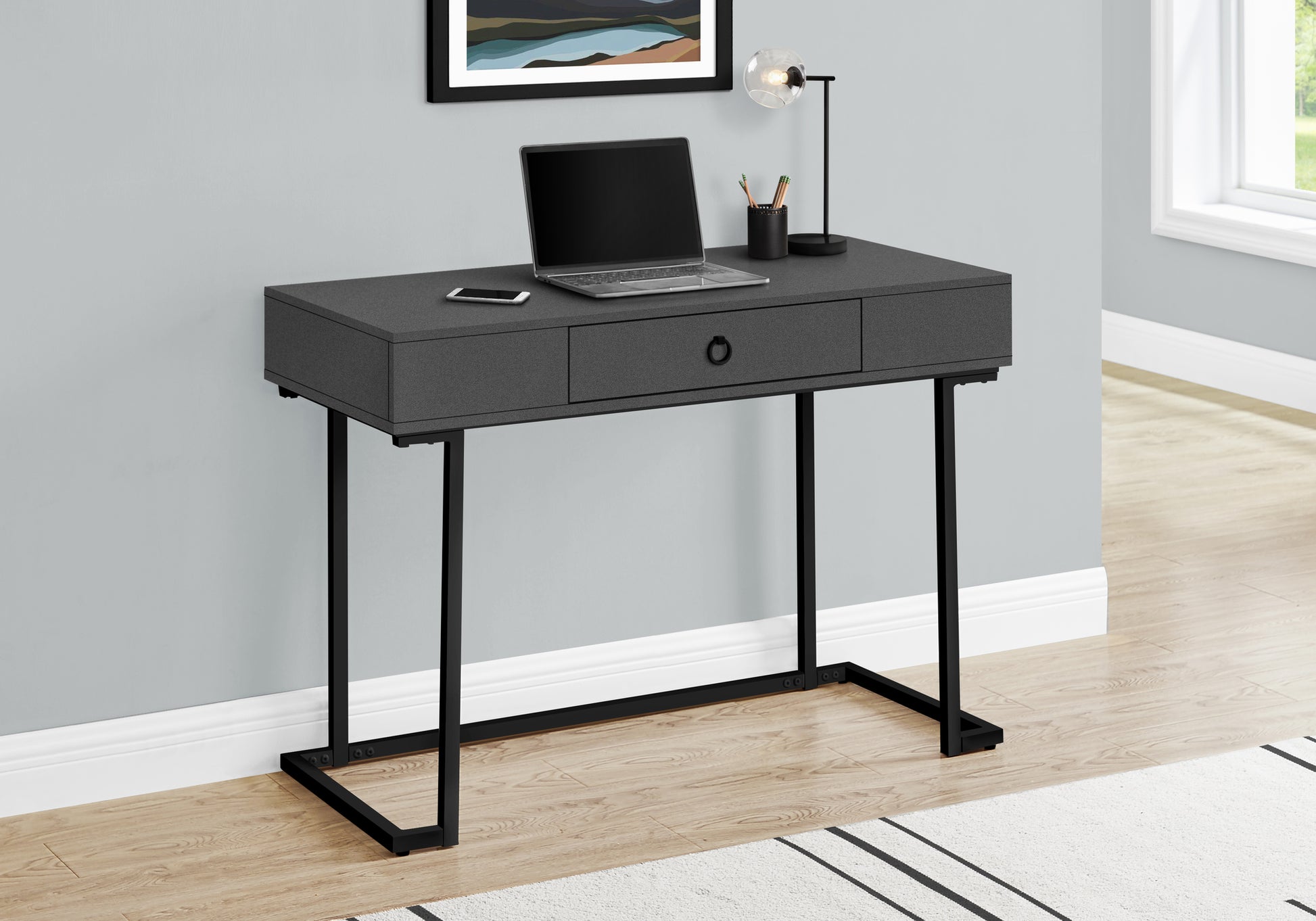 Charcoal gray modern desk with black metal legs laptop and lamp