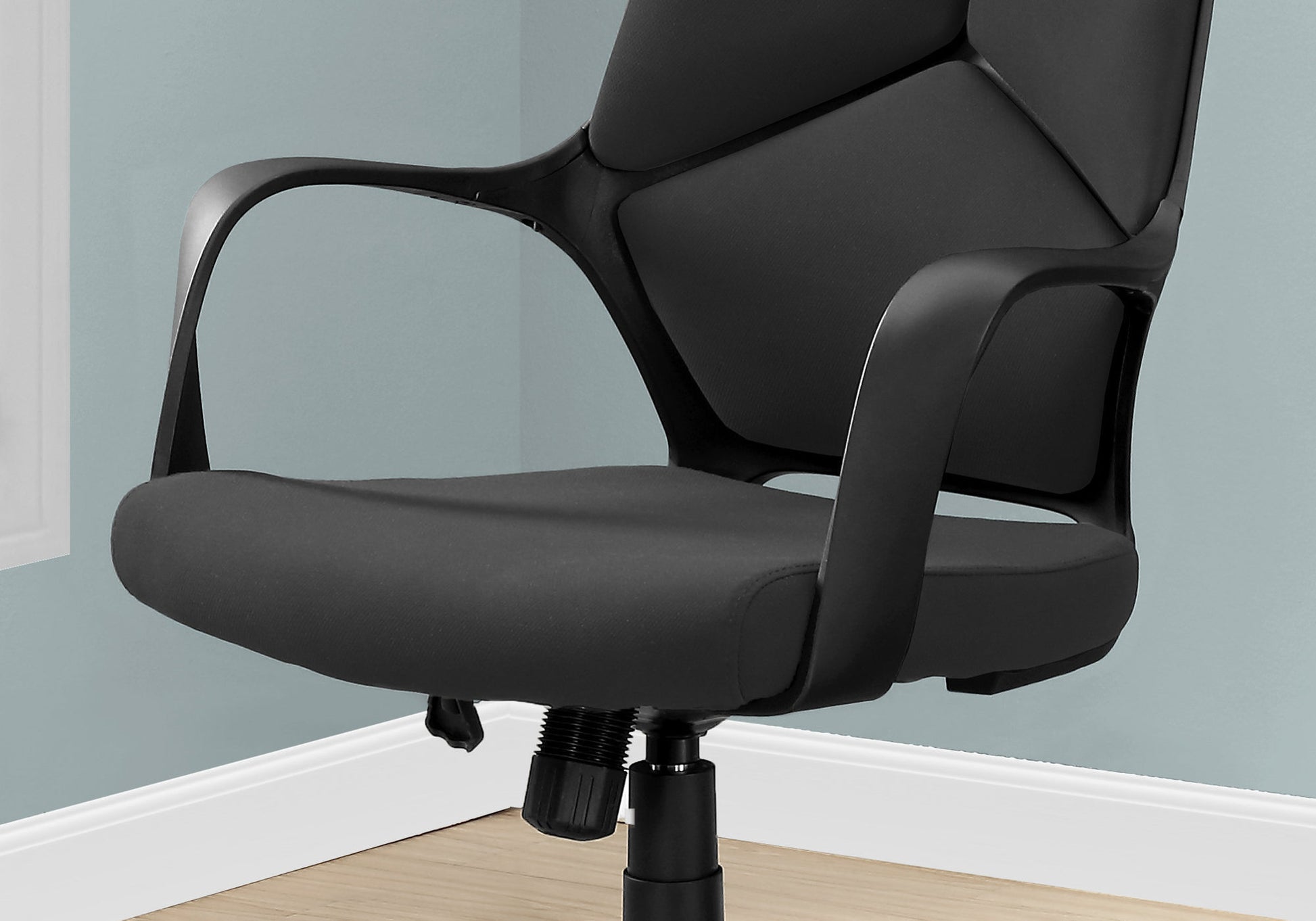 Closeup of a black mesh ergonomic office chair seat with curved armrests