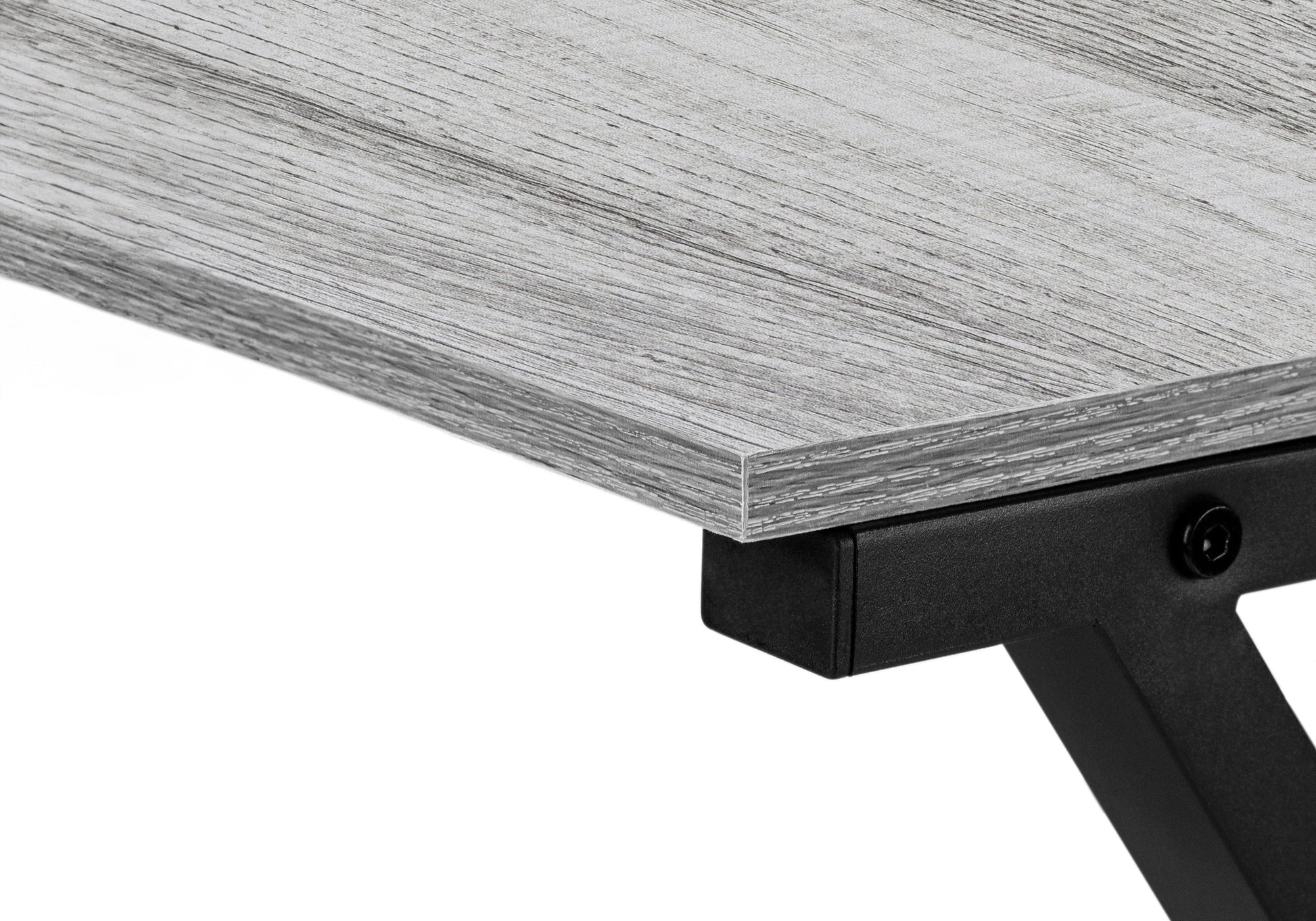 Closeup of a grey wood grain desk surface with black metal leg support