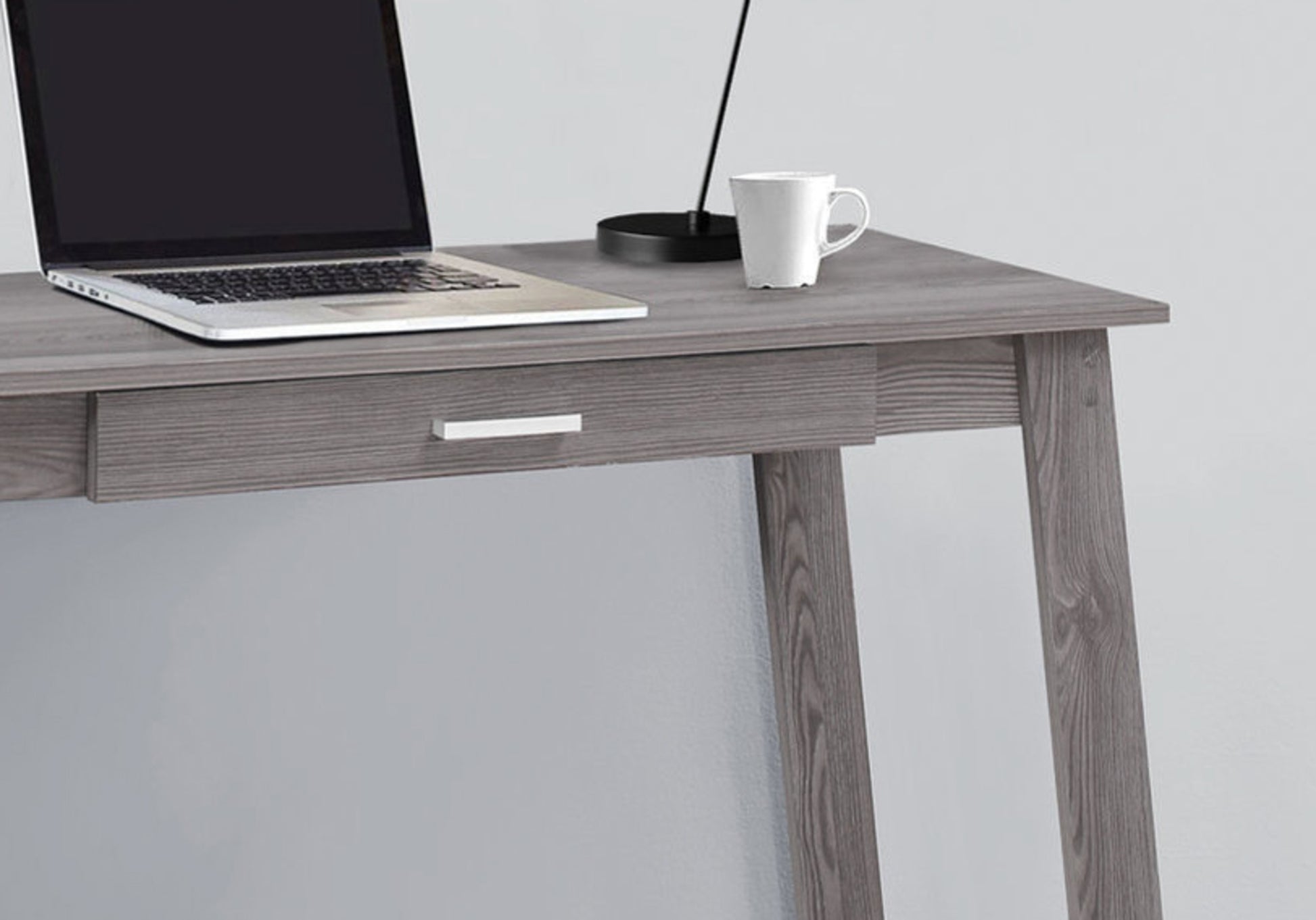 Modern gray wood writing desk with laptop and mug