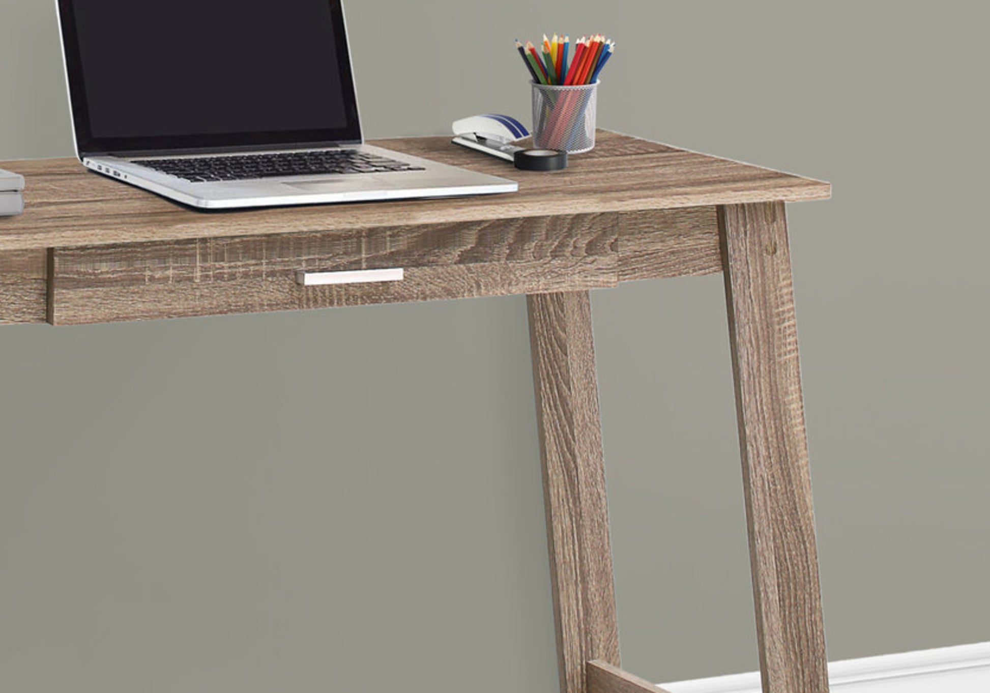Brown wood grain desk with a modern design and single drawer holding a laptop