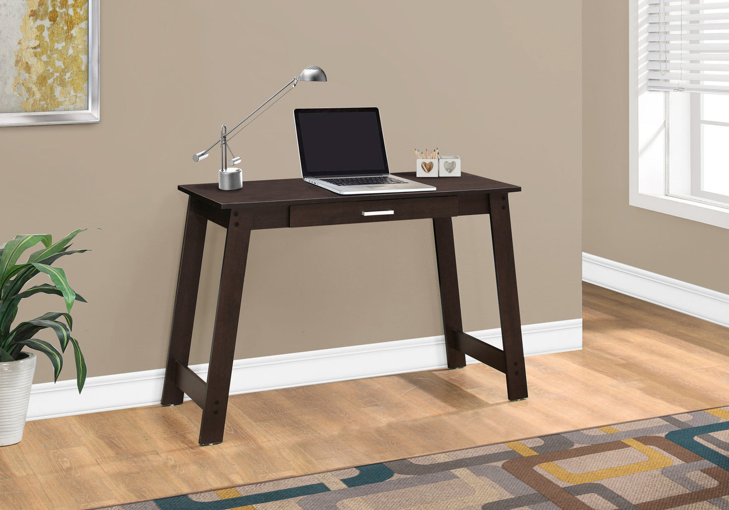 Dark brown modern writing desk with slim legs and one drawer