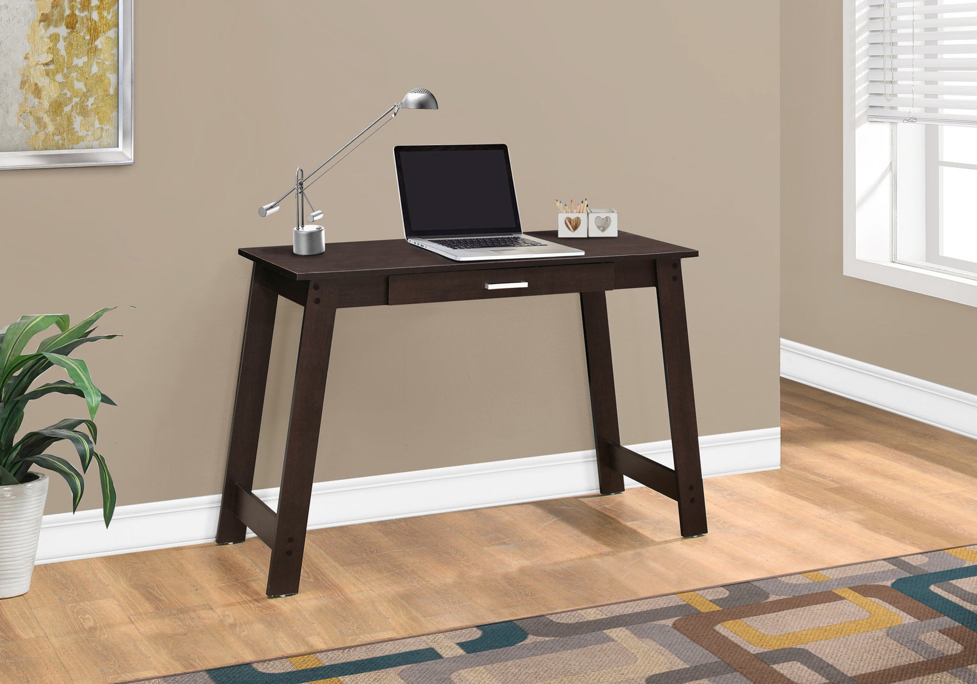 Dark brown modern writing desk with slim legs and one drawer