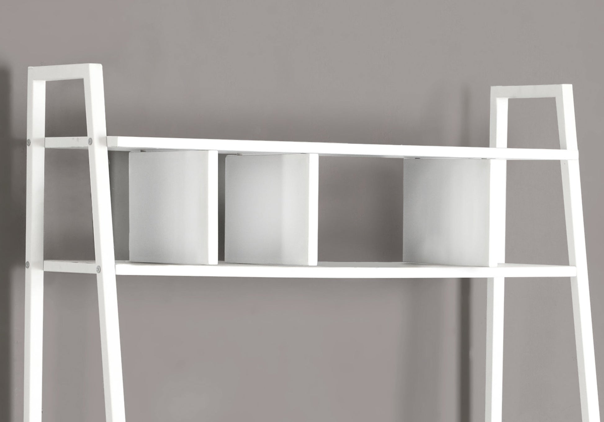 White leaning bookshelf with three cube compartments on a shelf ideal for modern homes