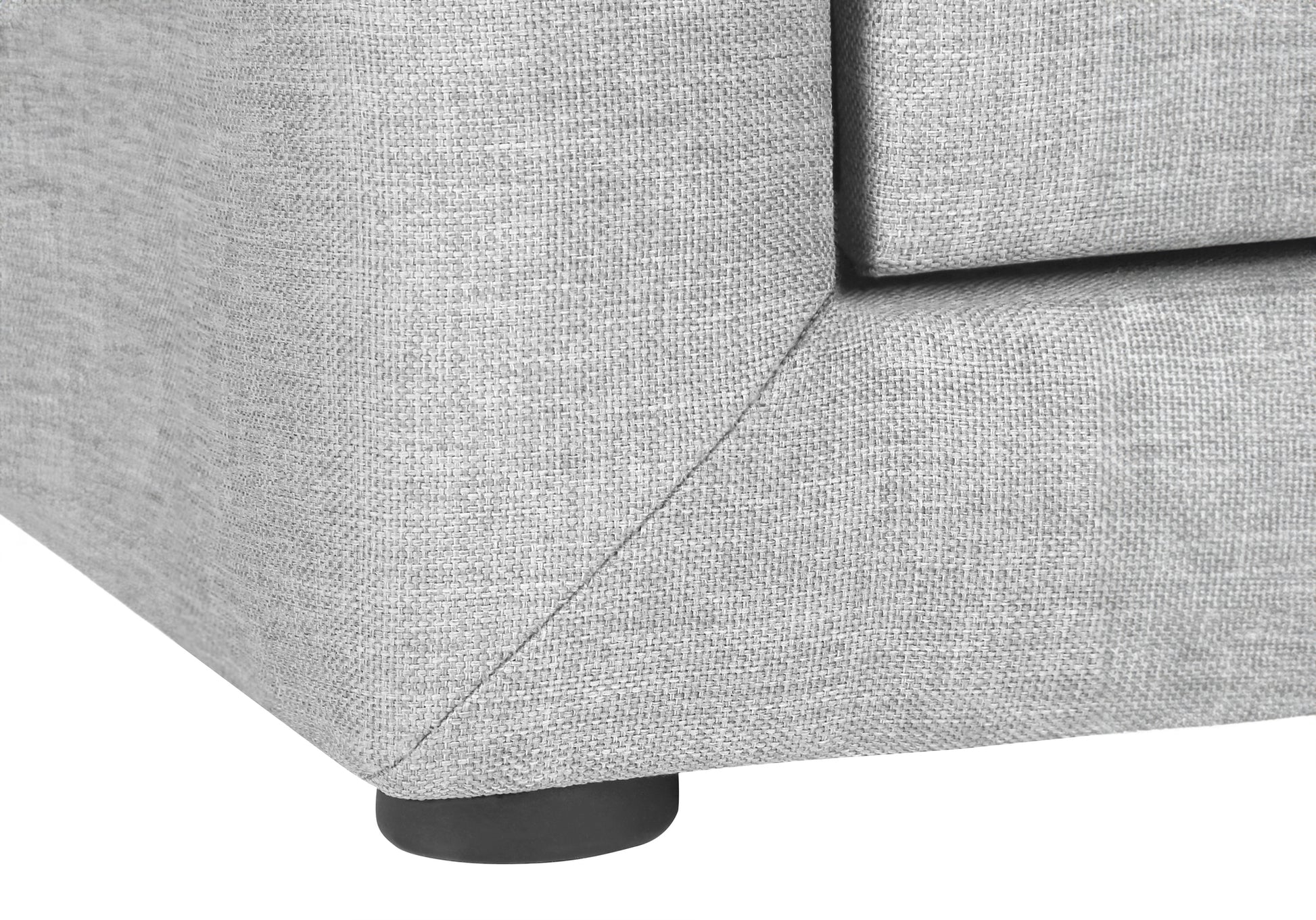 Closeup of light grey textured fabric sofa corner with a black wooden leg