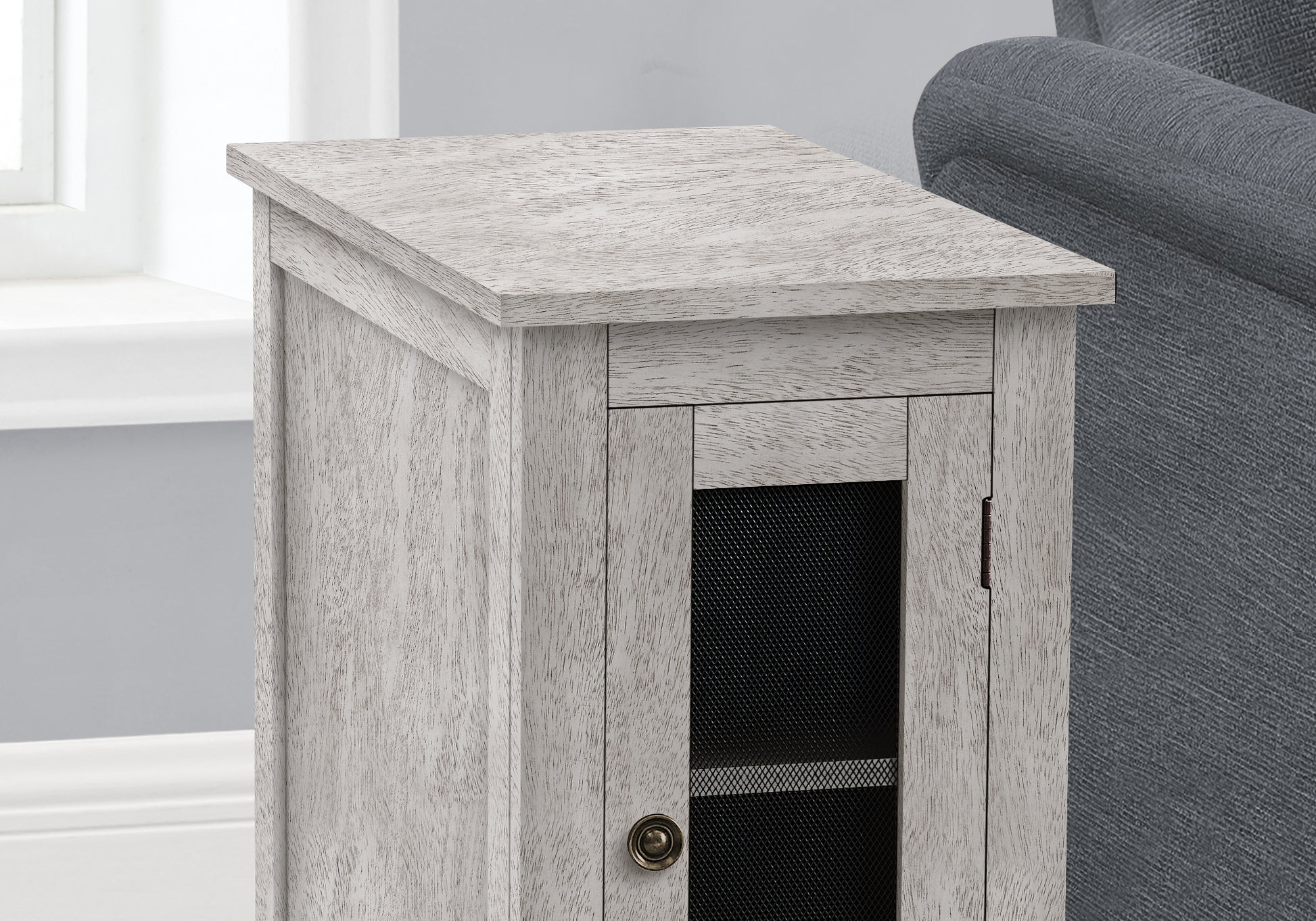 Distressed white wood accent cabinet with a single mesh door and antique brass knob