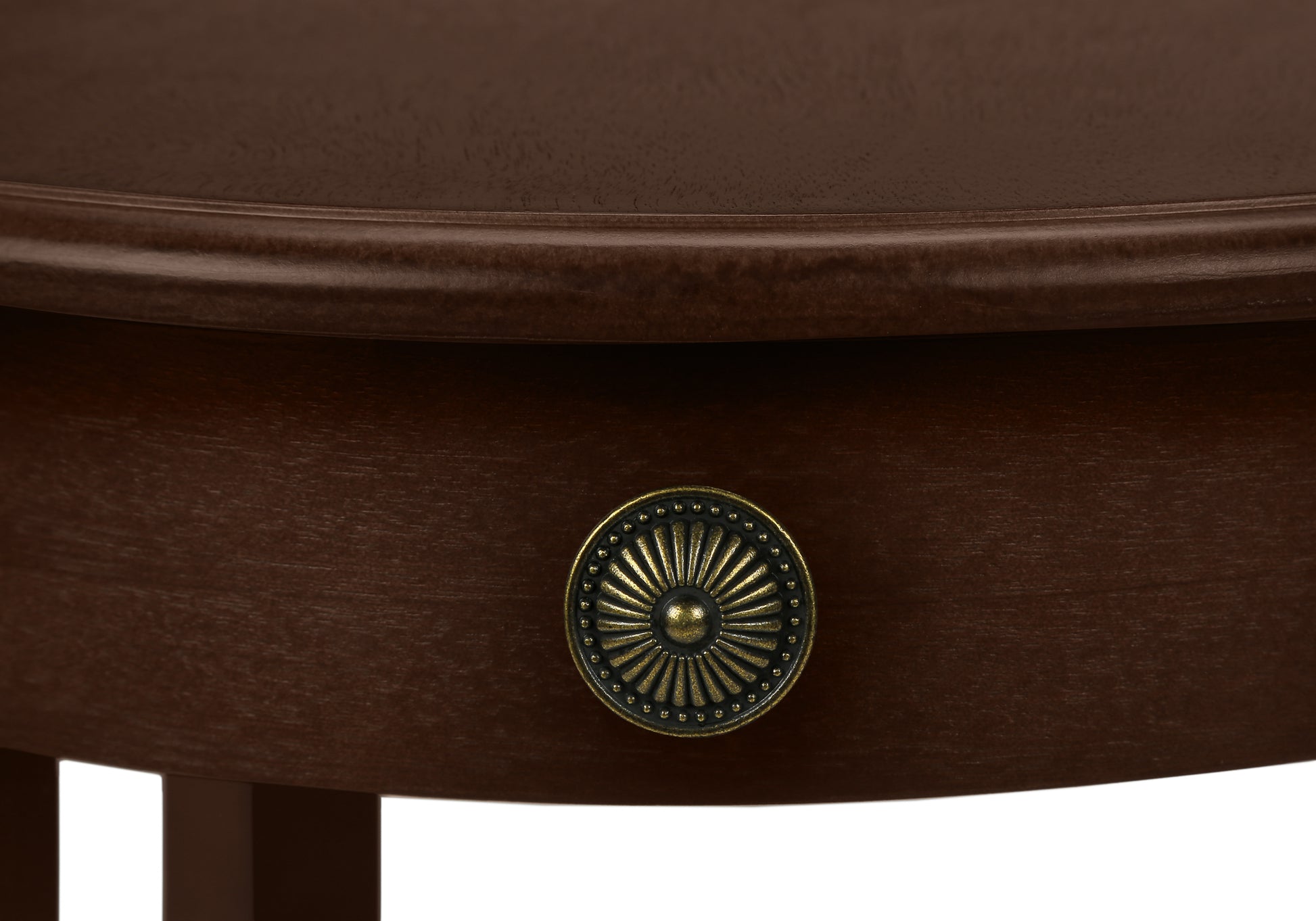 Antique brass sunburst drawer pull on a dark wood bedside table