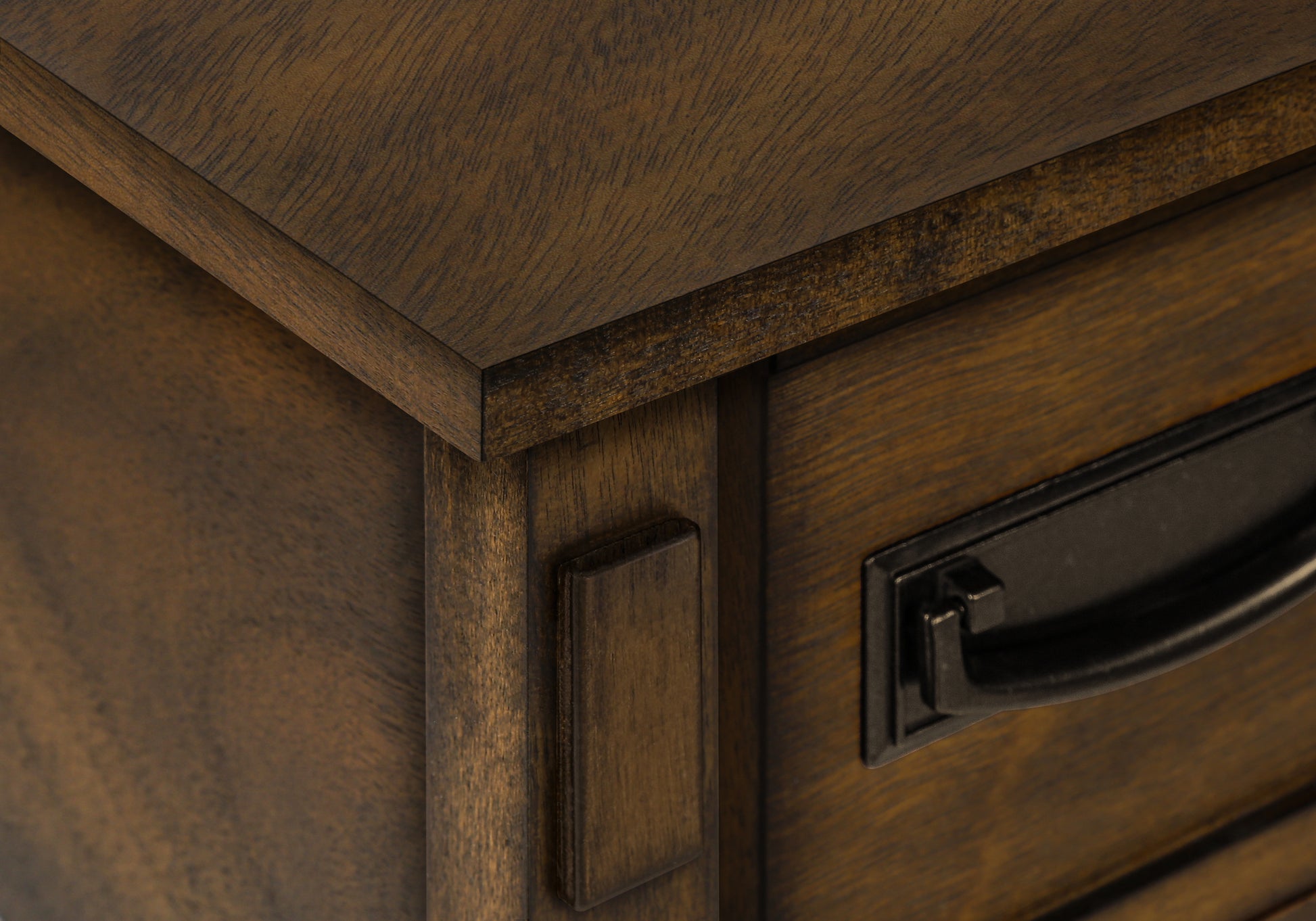 Closeup of dark wood dresser drawer with antique bronze handle