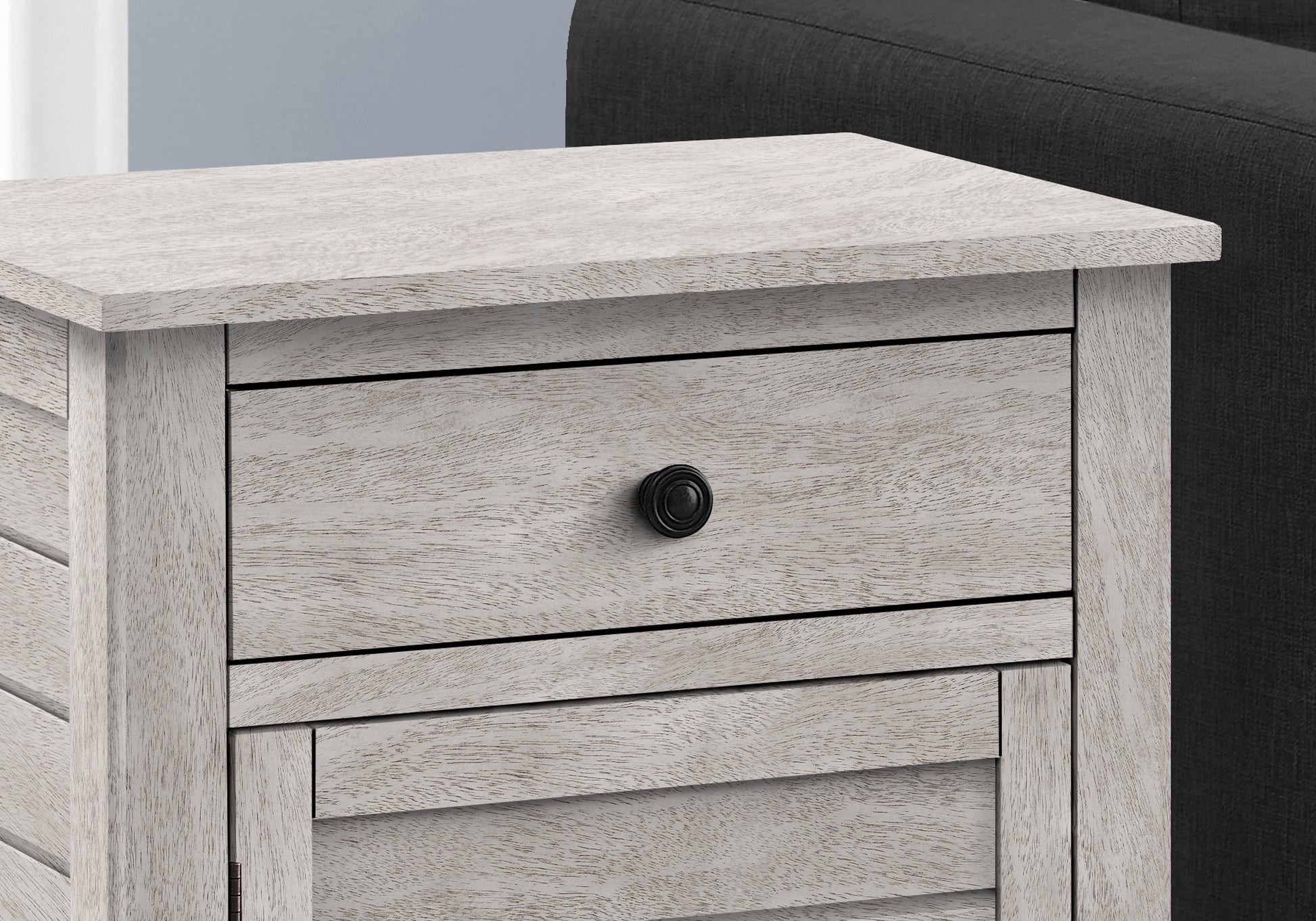 White washed wood bedside table with single black drawer pull