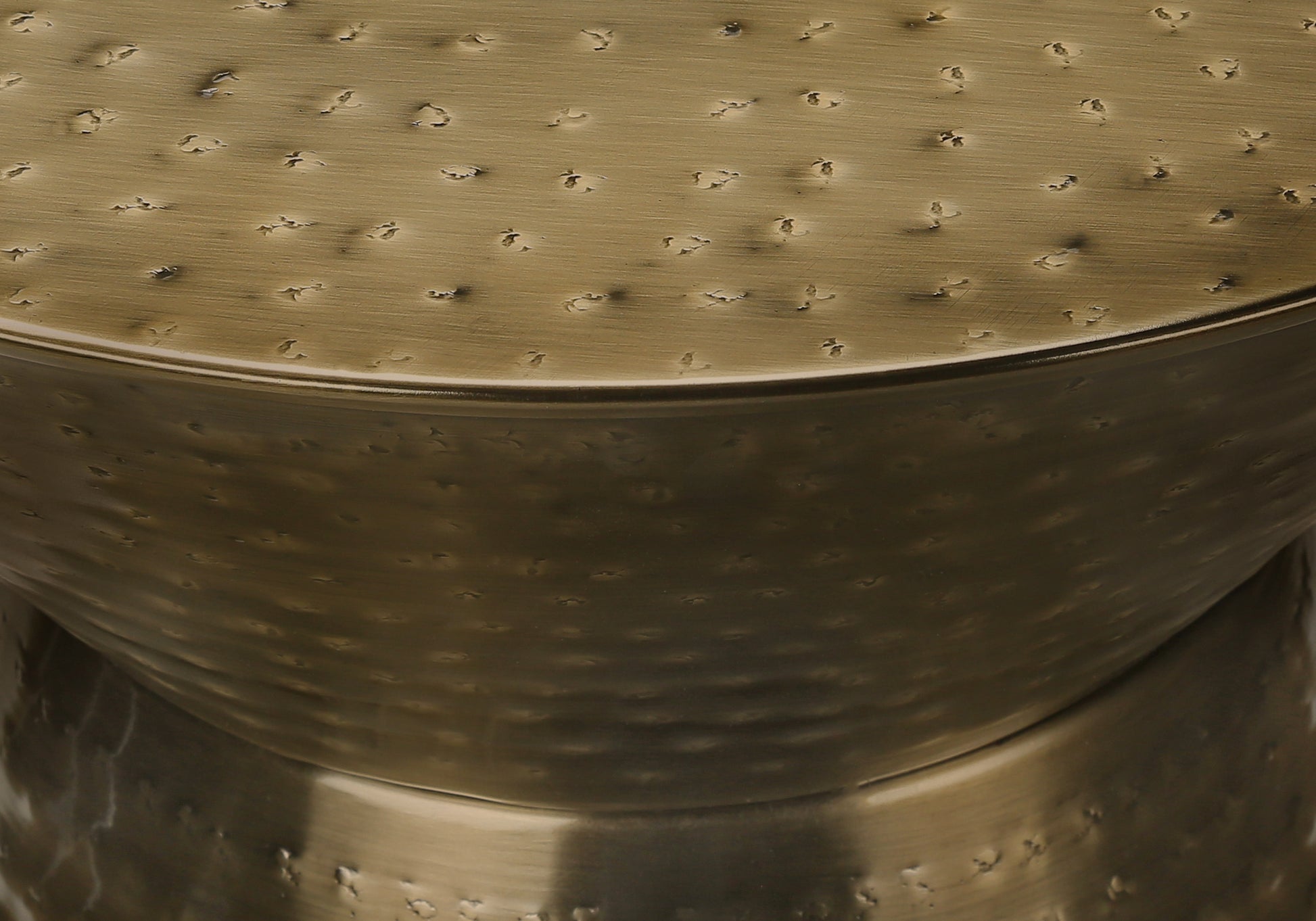 Textured brass accent table with a hammered finish and metallic sheen