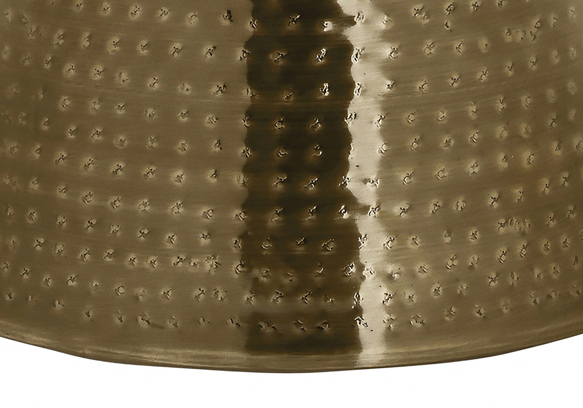 Hammered brass vase with a textured speckled surface and reflective highlights