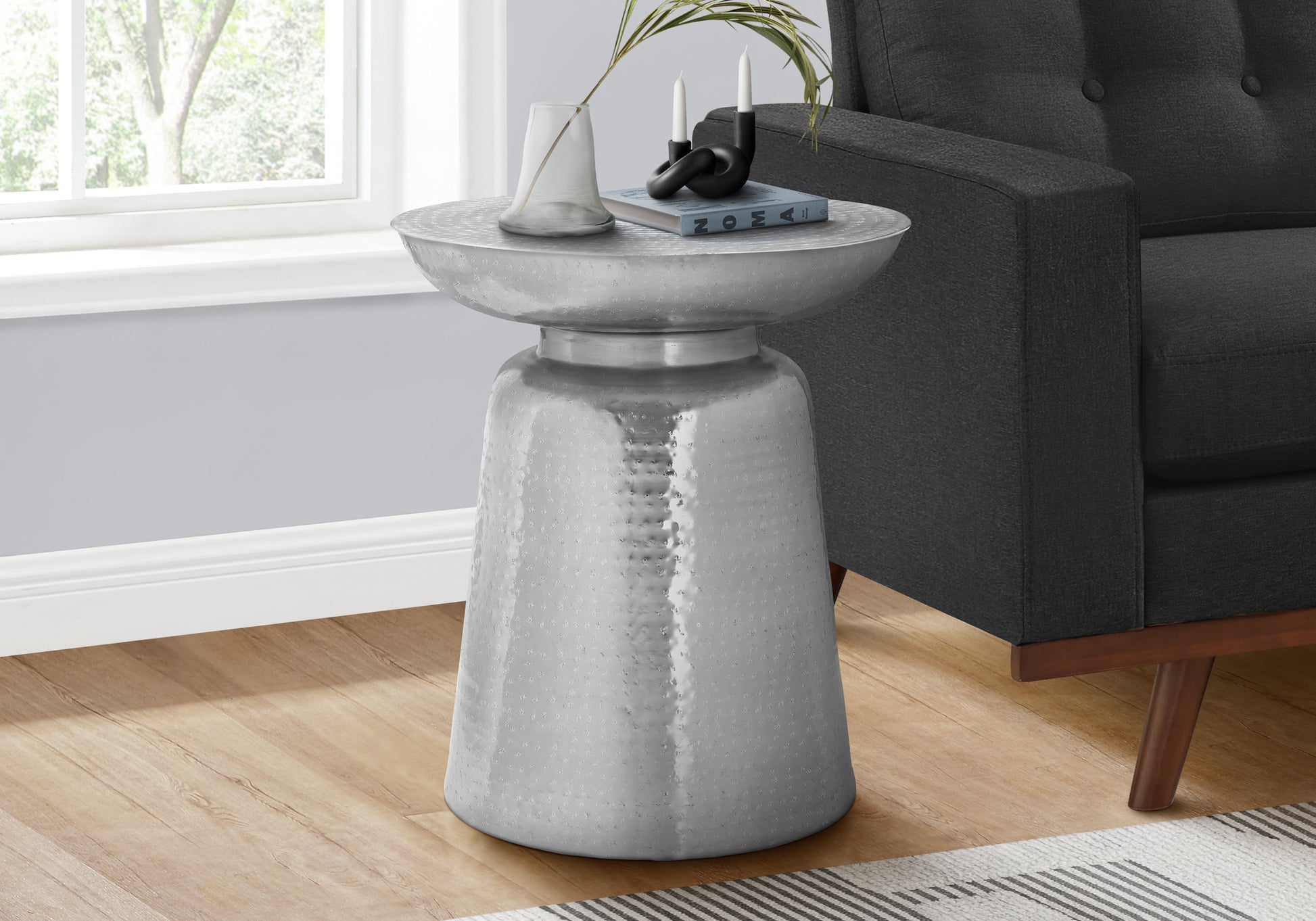 Hammered silver metal accent table with a wide rim and tapered base