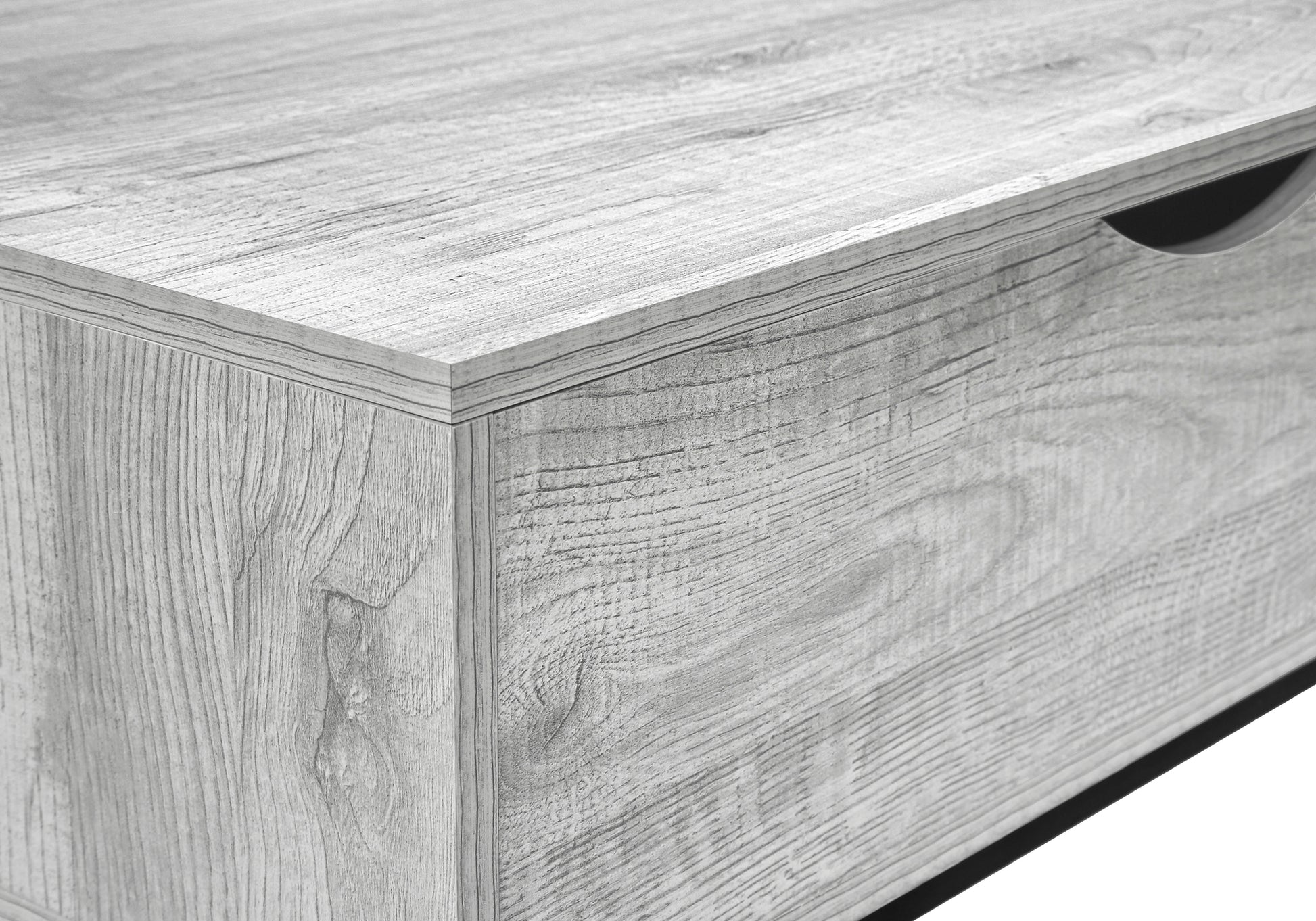 Closeup of a grey wood grain effect dresser drawer with a carved handle opening