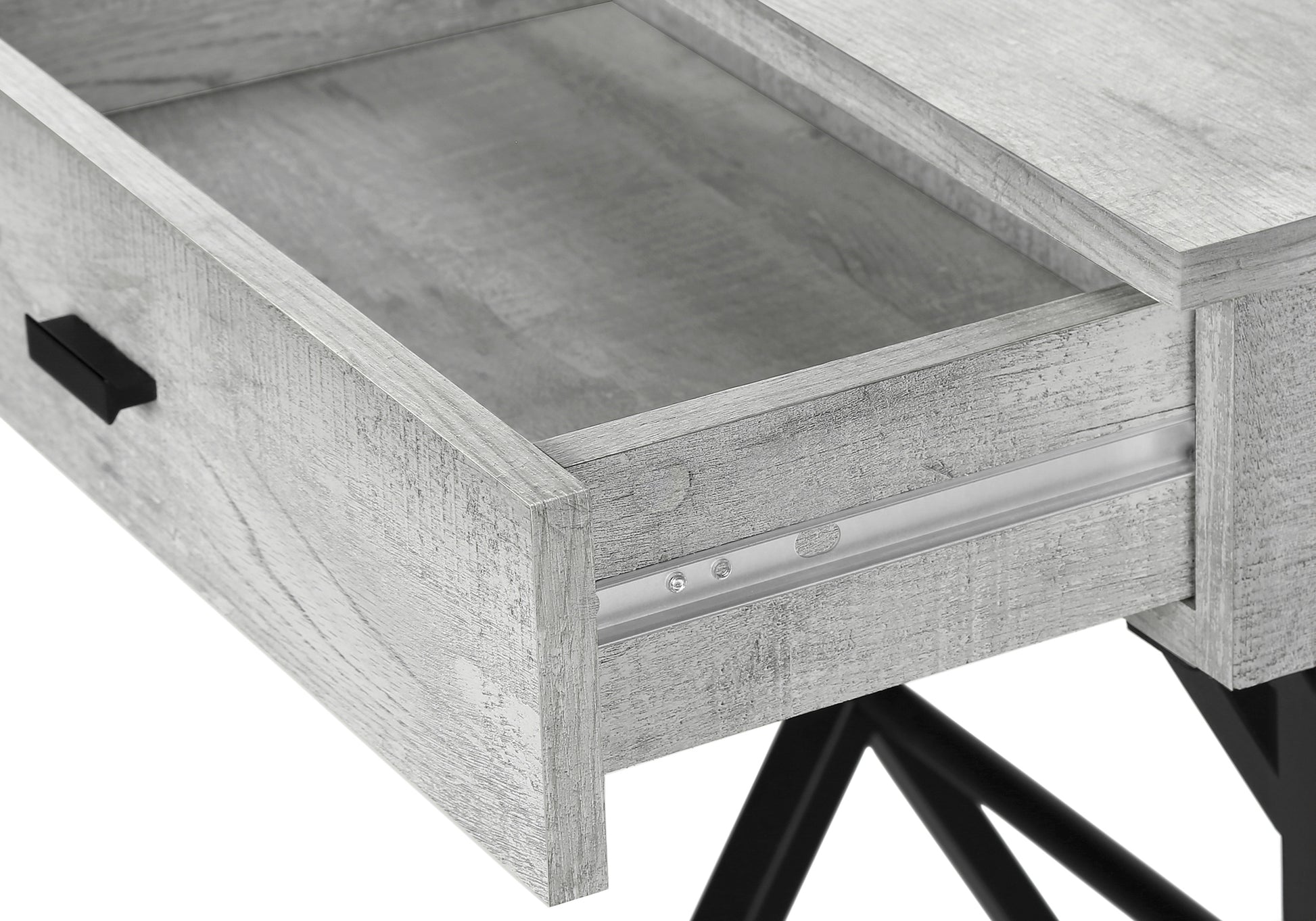 Closeup of a grey washed wood desk drawer with black handle and metal slides