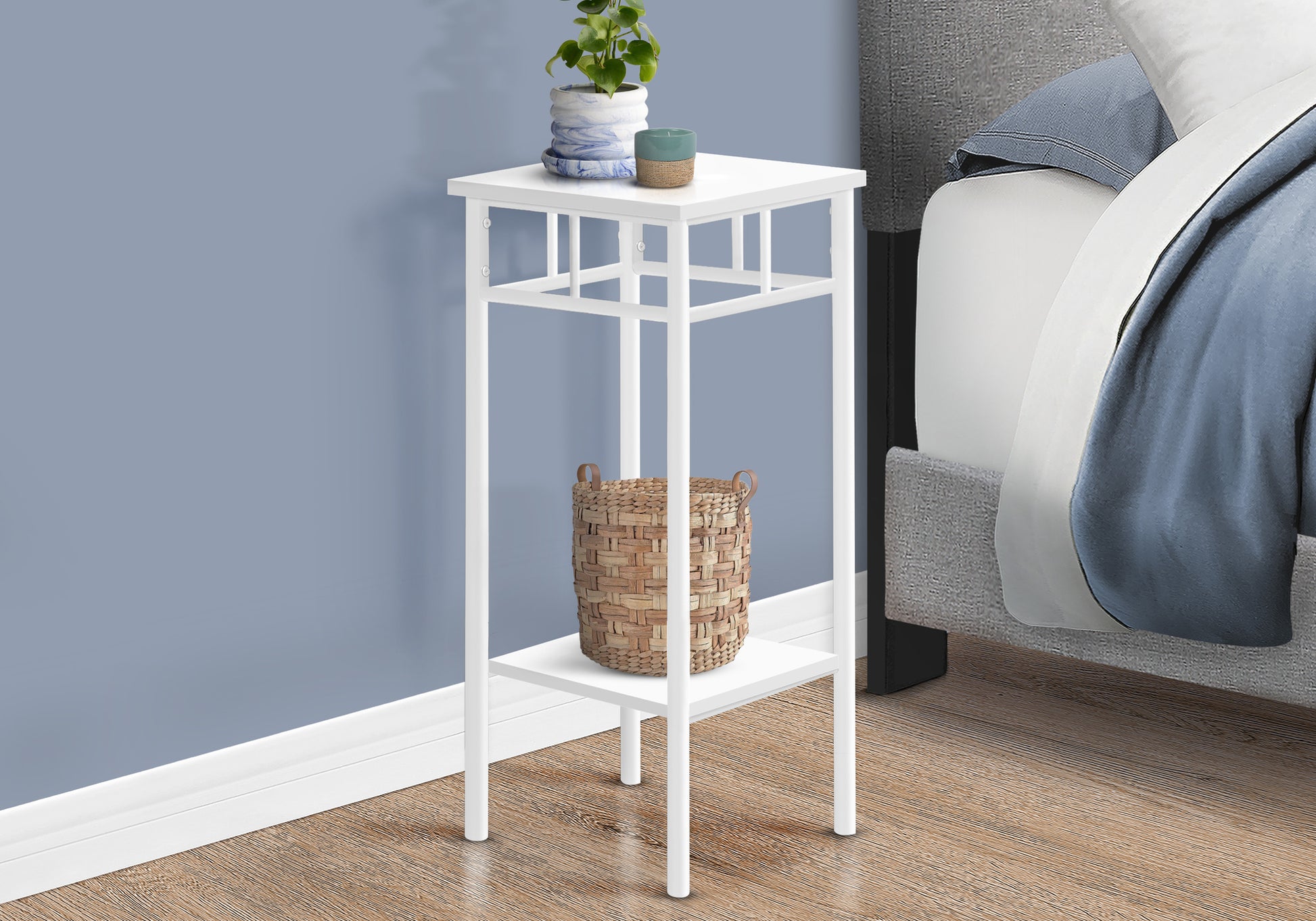White metal accent table with two shelves beside a bed