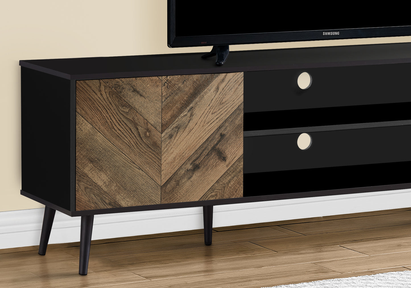 Black media console with distressed wood chevron door and tapered legs