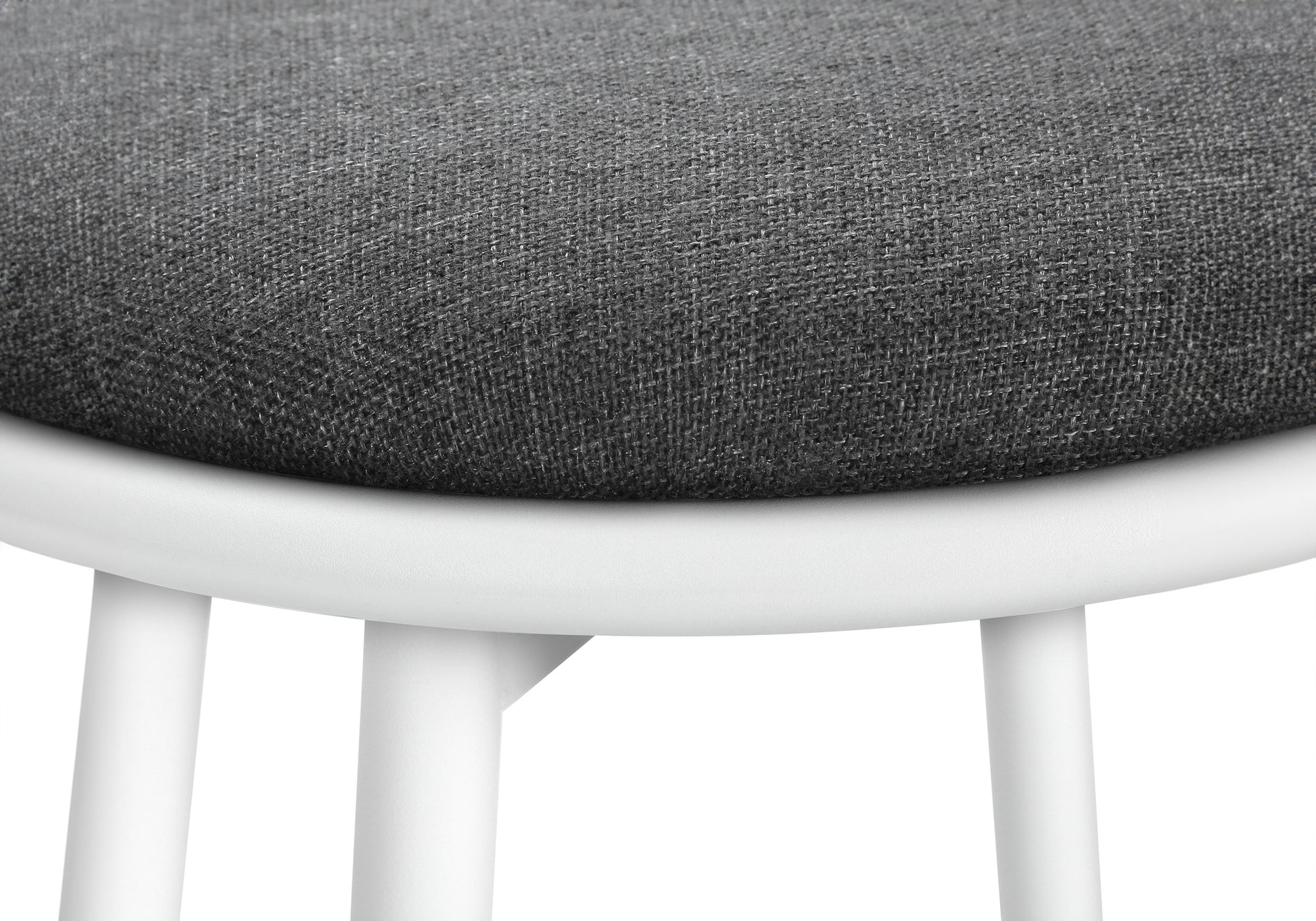 Closeup of a textured dark grey fabric seat on a white minimalist stool
