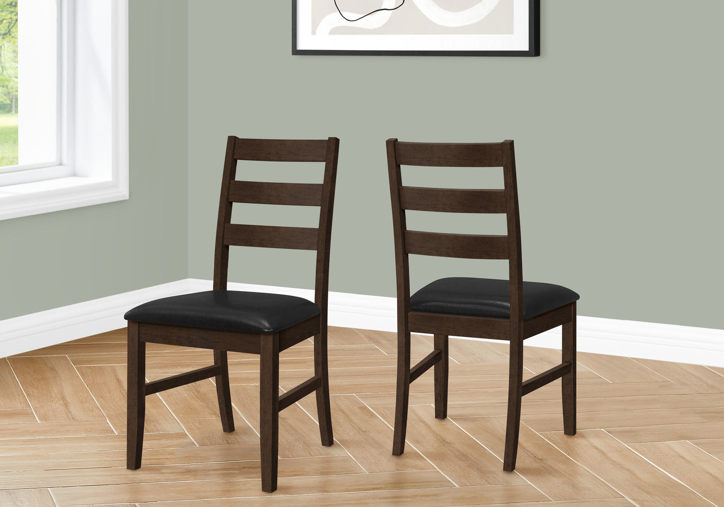 Two dark brown wooden dining chairs with black faux leather seats