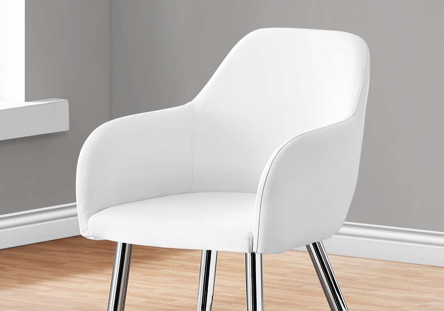 White faux leather dining chair with curved back and chrome legs