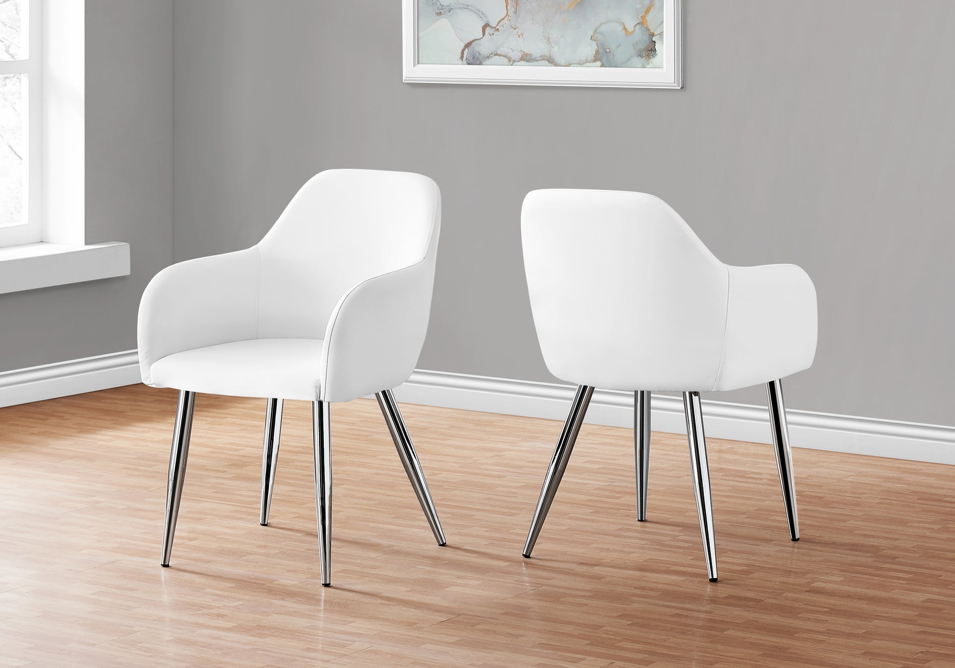Two white faux leather dining chairs with chrome legs
