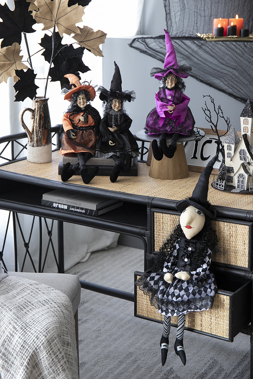 Three Halloween witch dolls in orange and black with pointy hats and festive attire