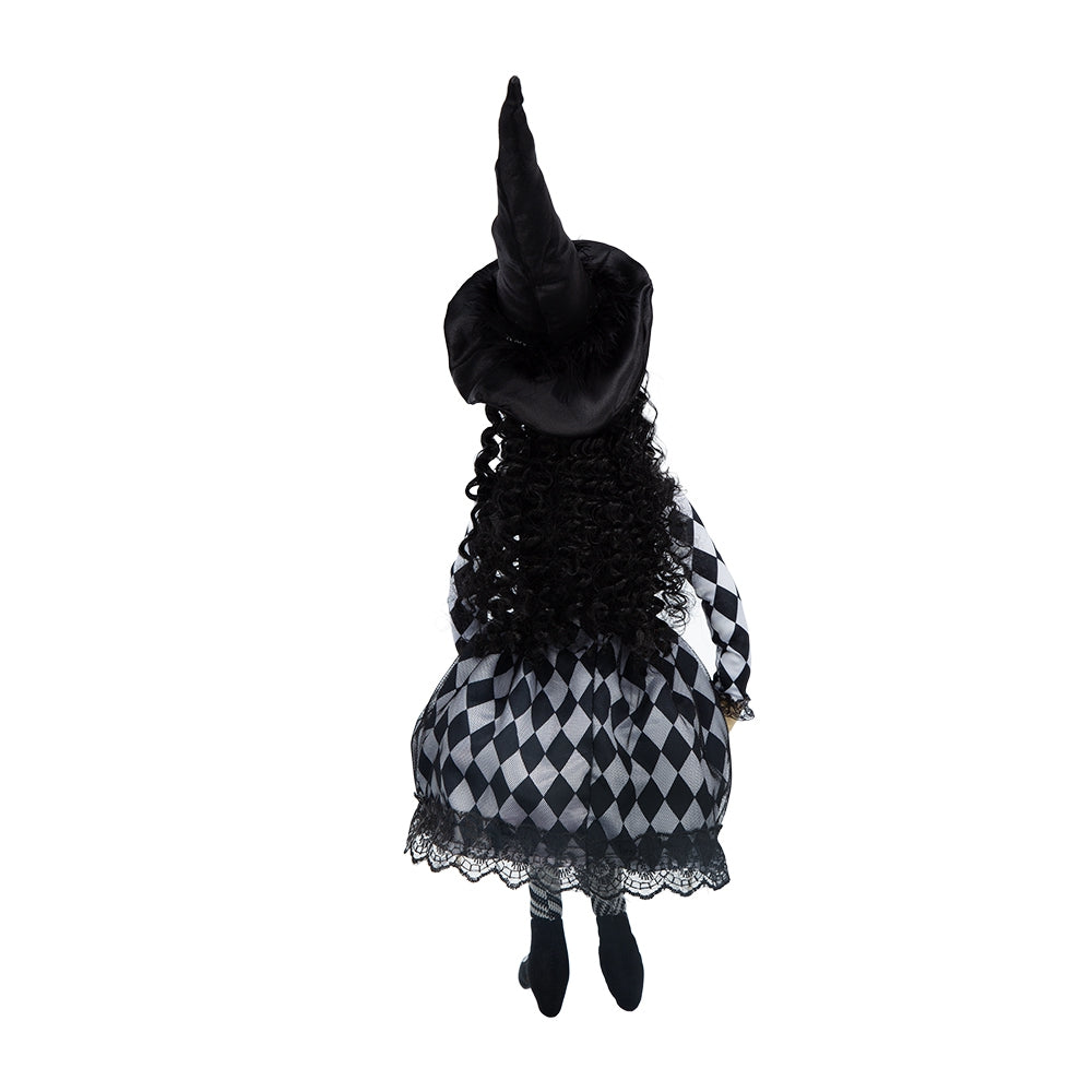 Back view of a black witch doll with long curly hair and a harlequin print dress