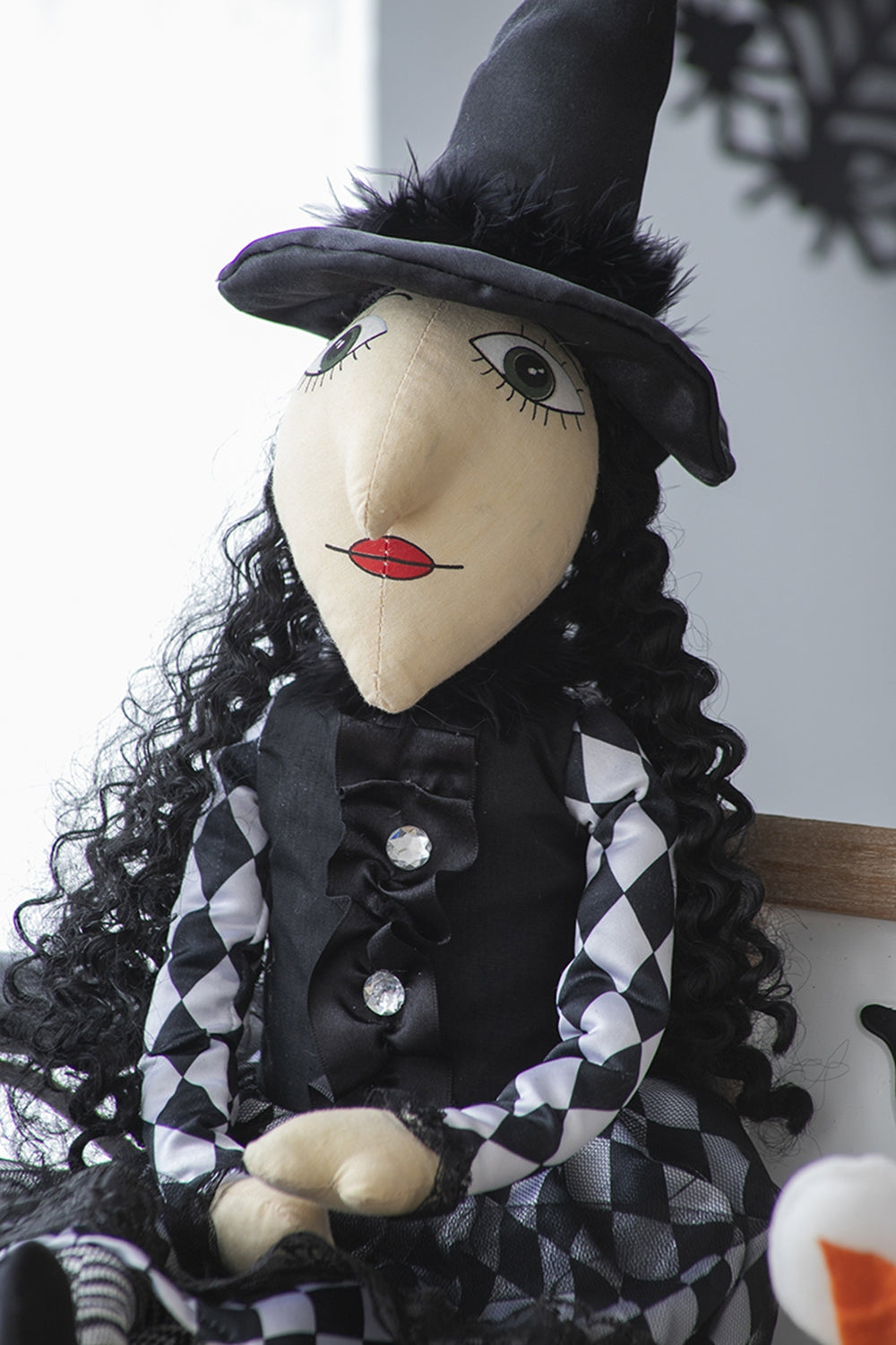 Fabric witch doll with black hat curly hair and diamondpatterned dress