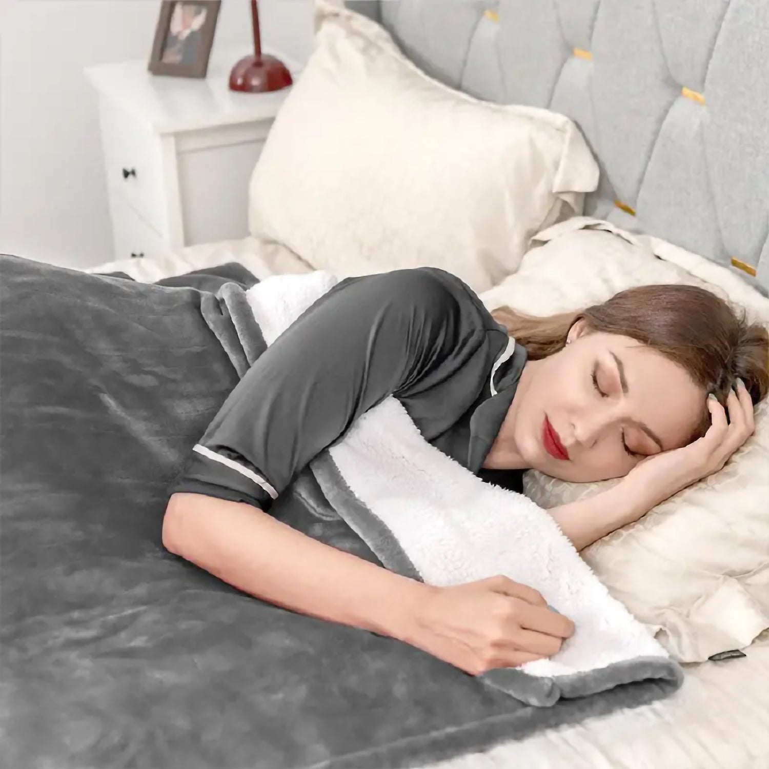 Woman sleeping under plush grey sherpa lined blanket for ultimate comfort