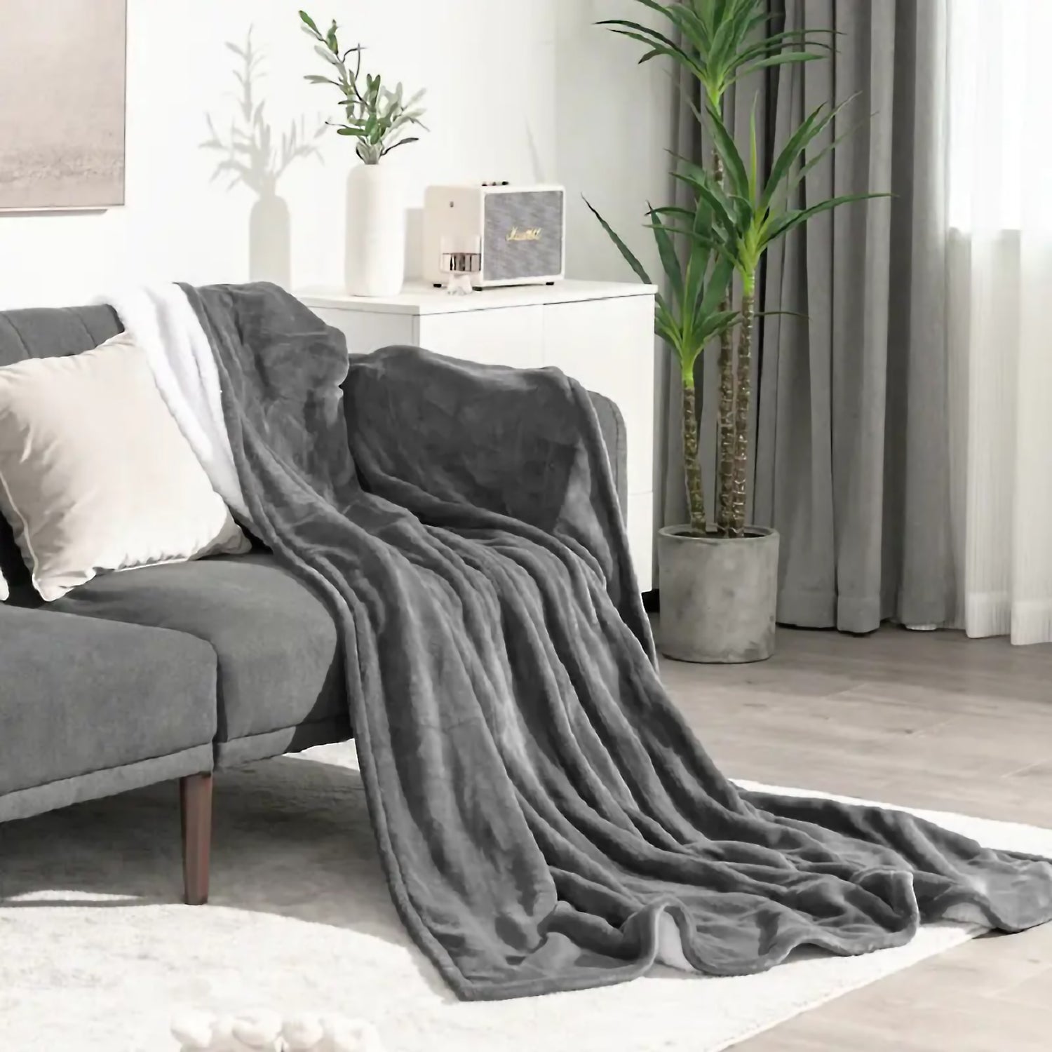 Plush grey fleece blanket draped over a sofa perfect for cozy evenings