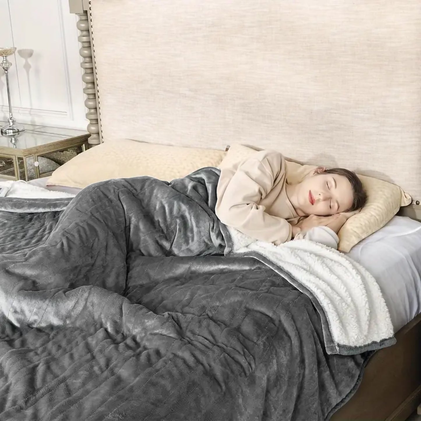 Cozy grey sherpa throw blanket with quilted pattern draped over a sleeping woman