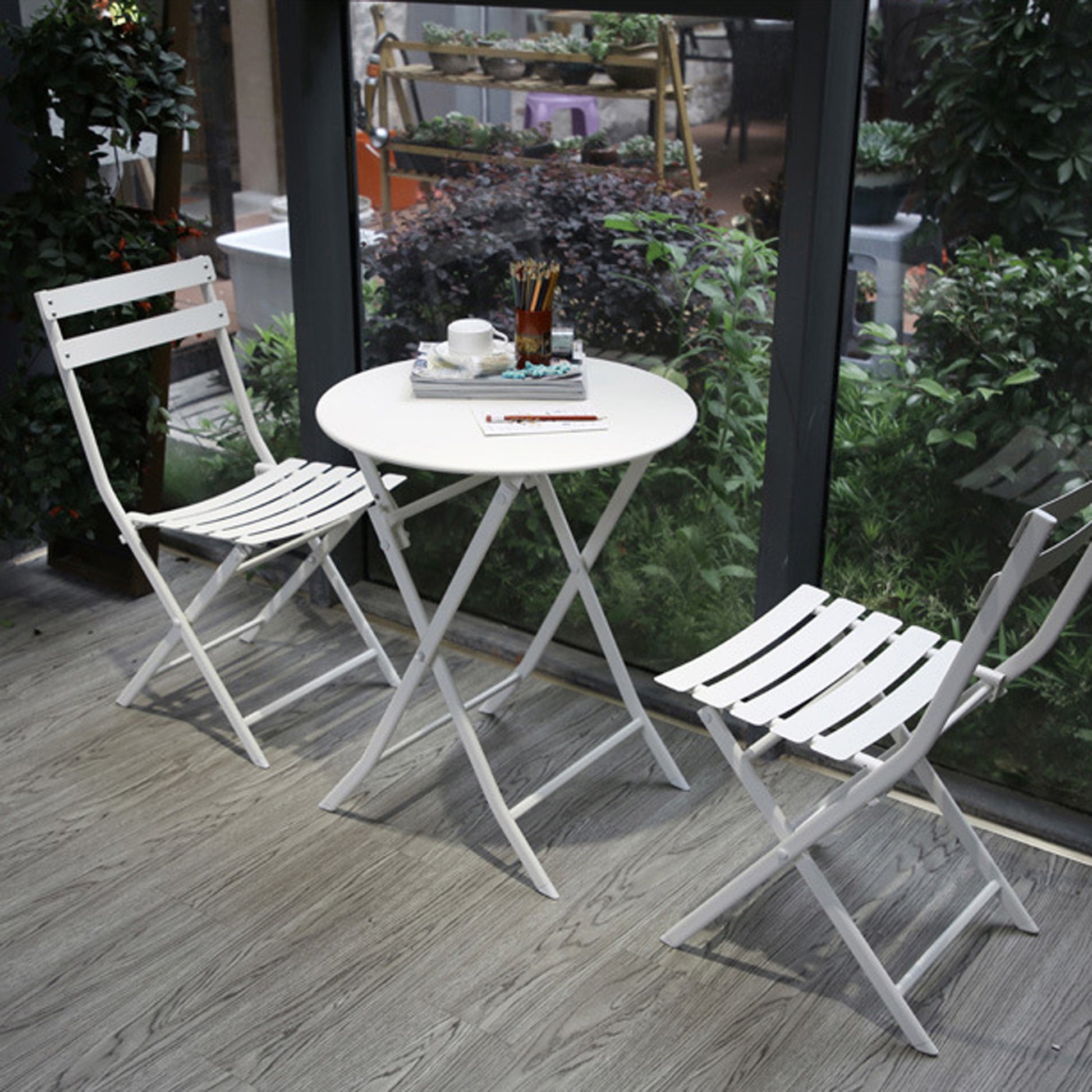 White metal folding bistro set with slatted seats and round tabletop