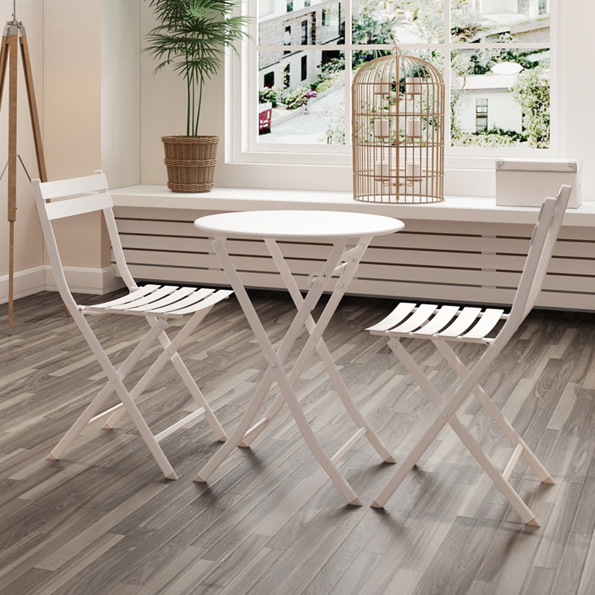 White metal bistro set with two folding chairs and a round table for outdoor seating