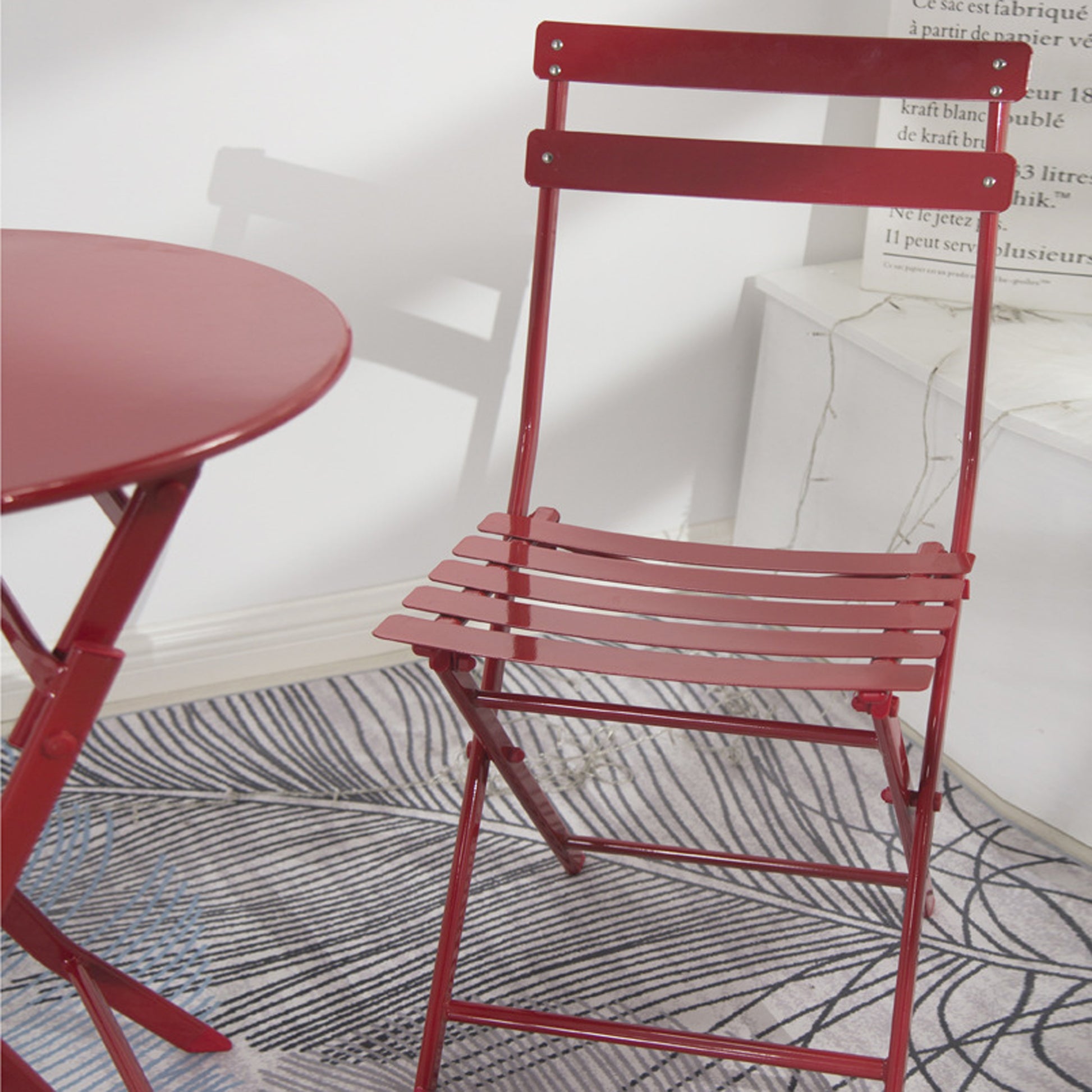 Red metal folding chair with slatted seat and back for outdoor seating
