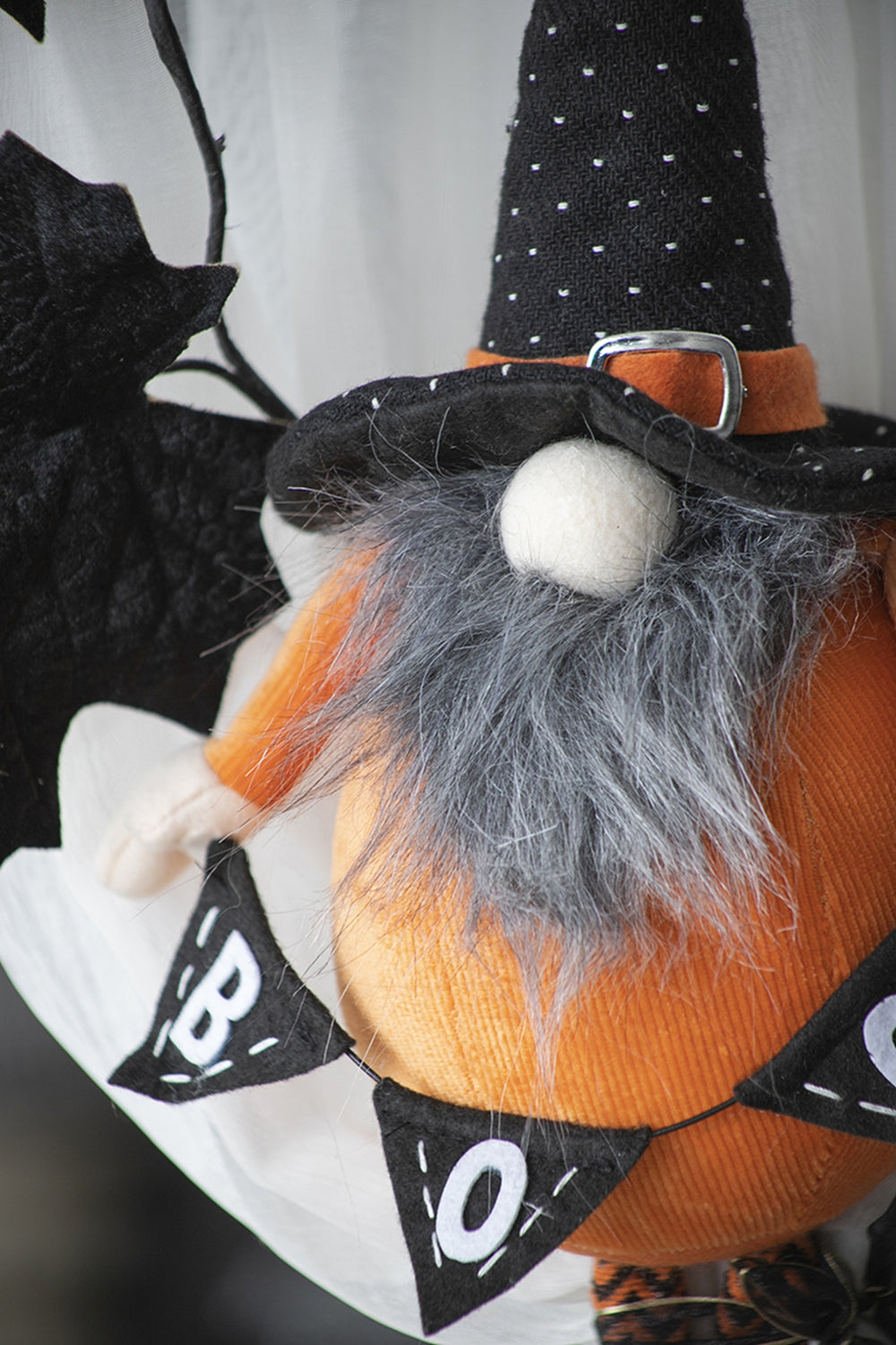 Orange plush Halloween gnome with black polka dot witch hat and gray beard