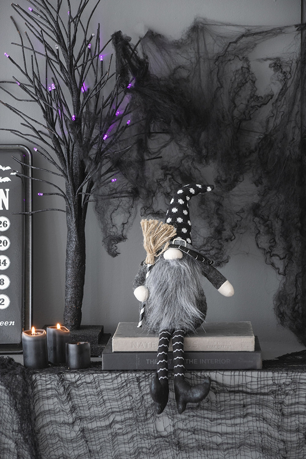 Halloween gnome with grayscale fabric body and polka dot hat holding a broom