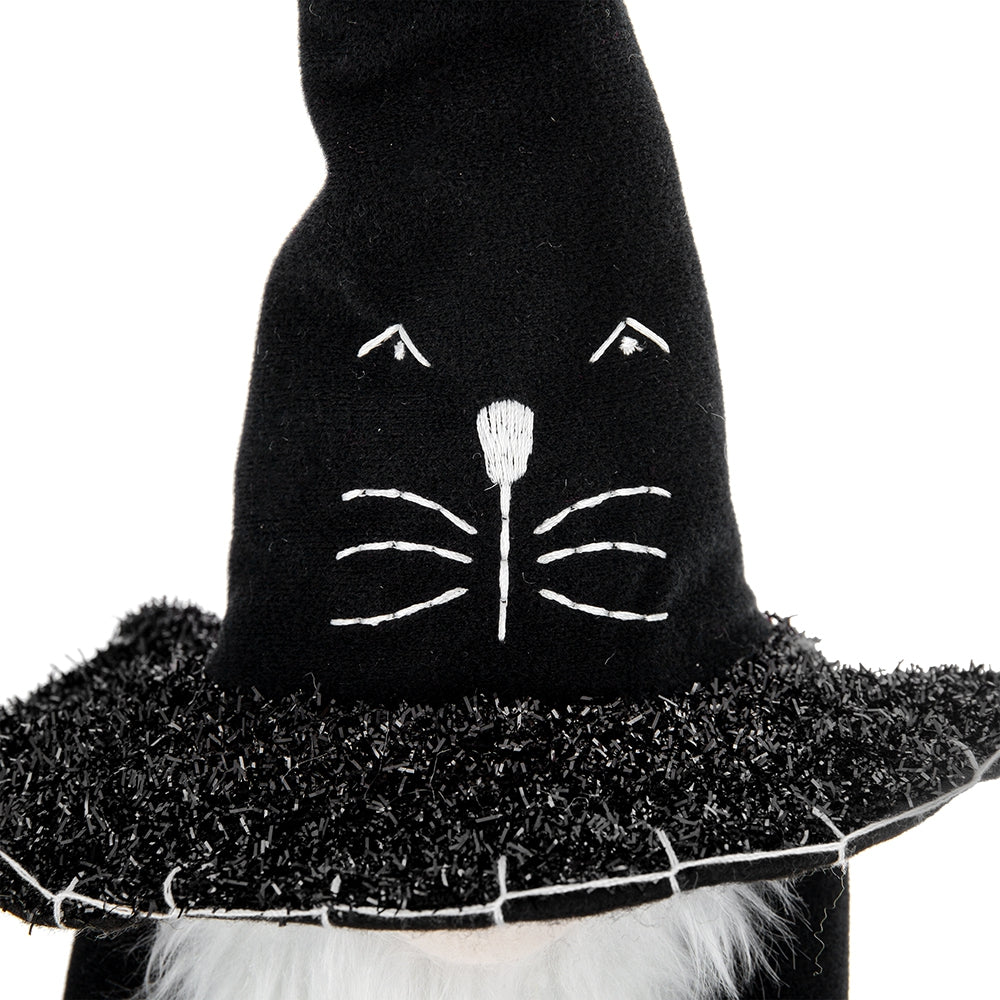 Black felt gnome wearing a witch hat with embroidered cat face and white beard