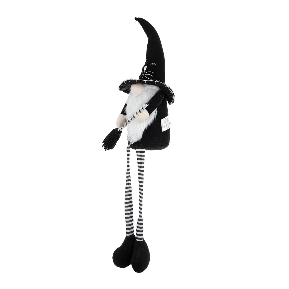 Black plush witch gnome with a white beard and striped legs holding a broom