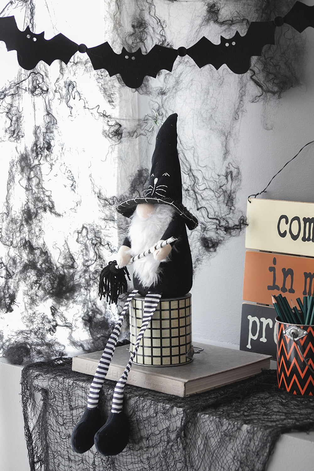 Halloween gnome figurine with black hat and striped legs a festive decoration